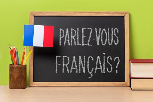 A blackboard that translates to ‘Do you speak French?’