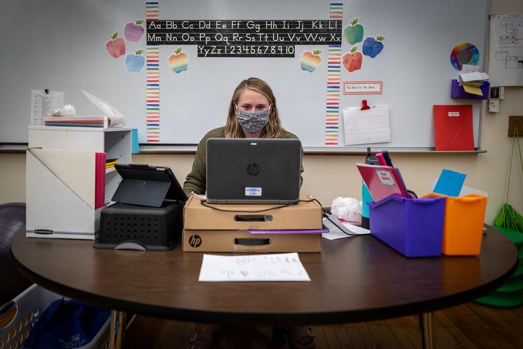 Teacher in a classroom conducting lessons online