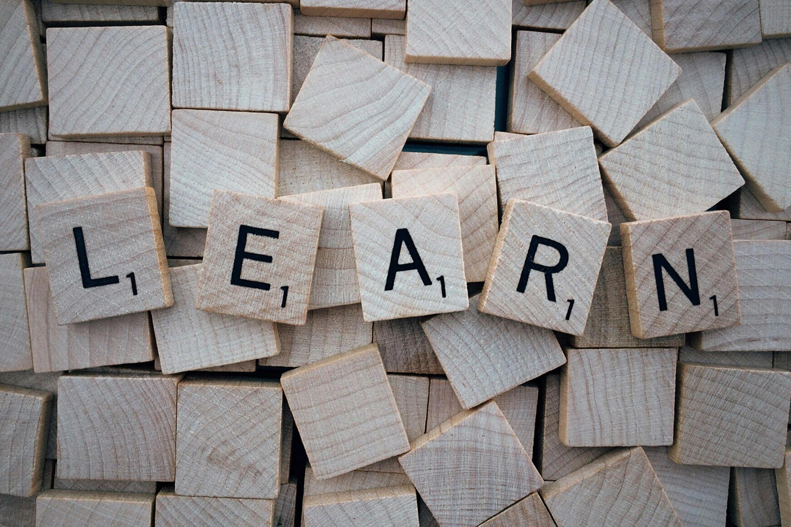 Wooden letter blocks arranged in a scattered pattern.