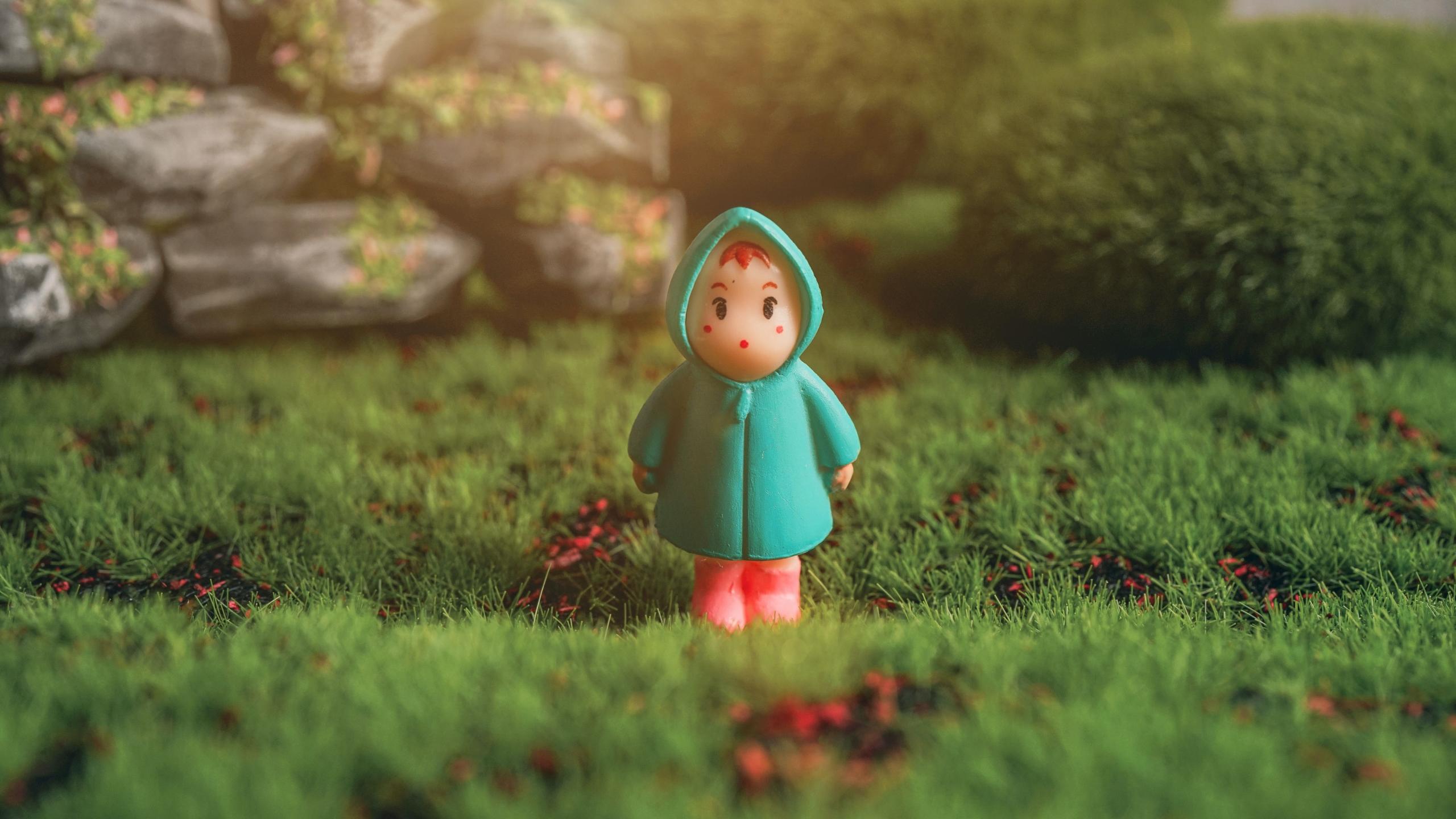 An animation of a red-haired girl in a green dress standing on green grass