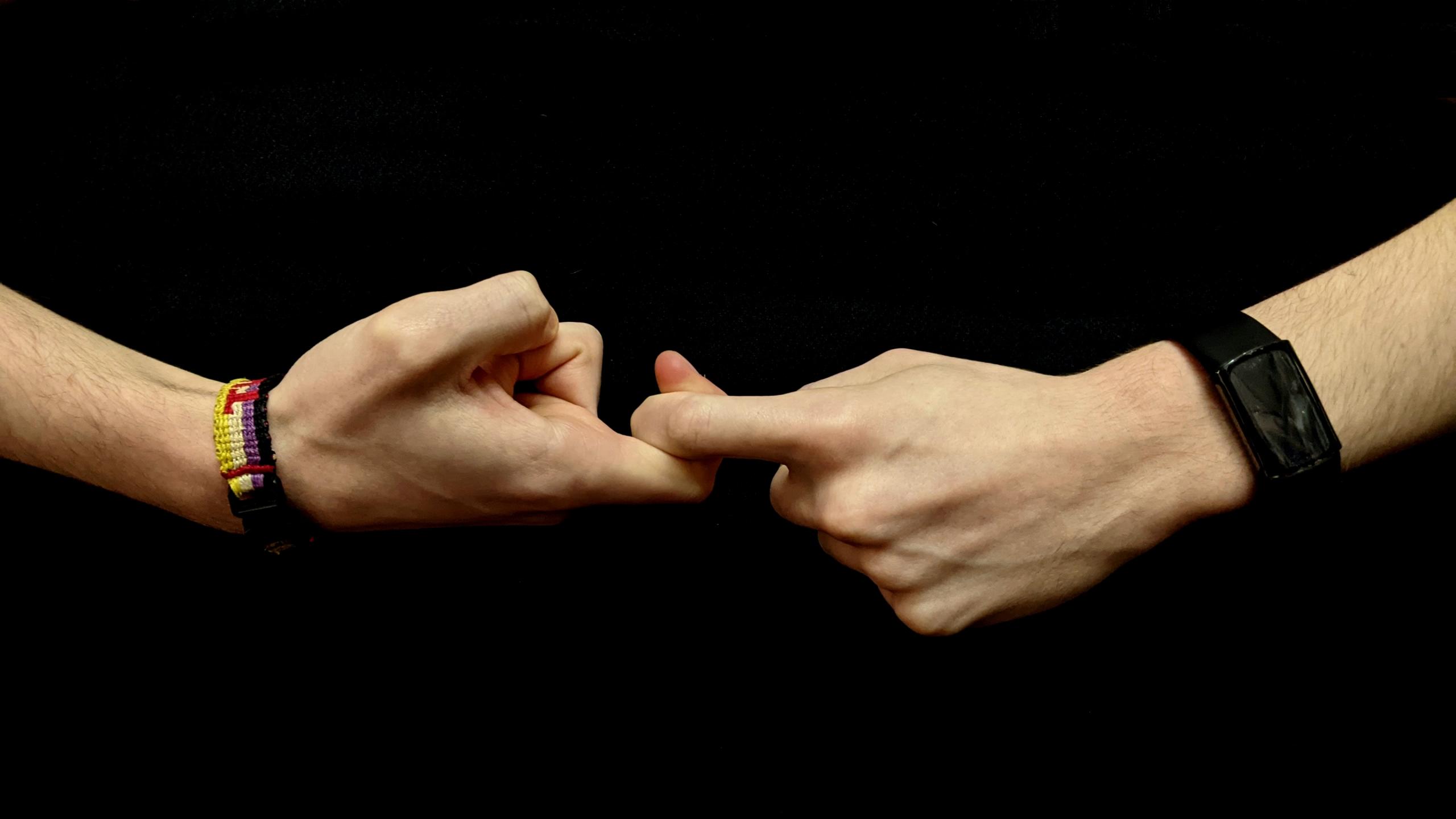 Two hands with the index fingers interlocked in one another
