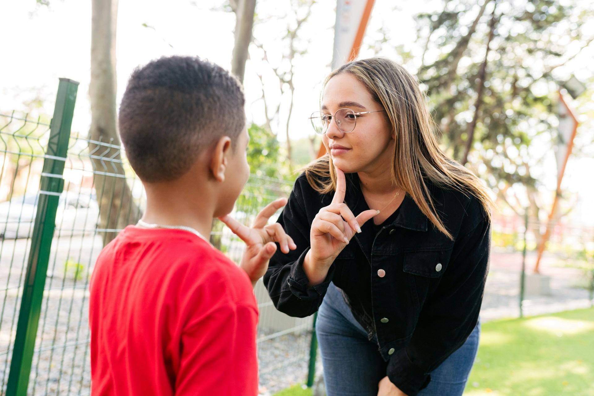 A girl and boy practicing sign language