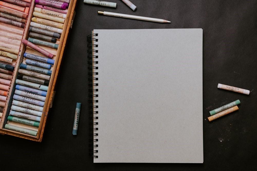 A white spiral notebook with different colors
