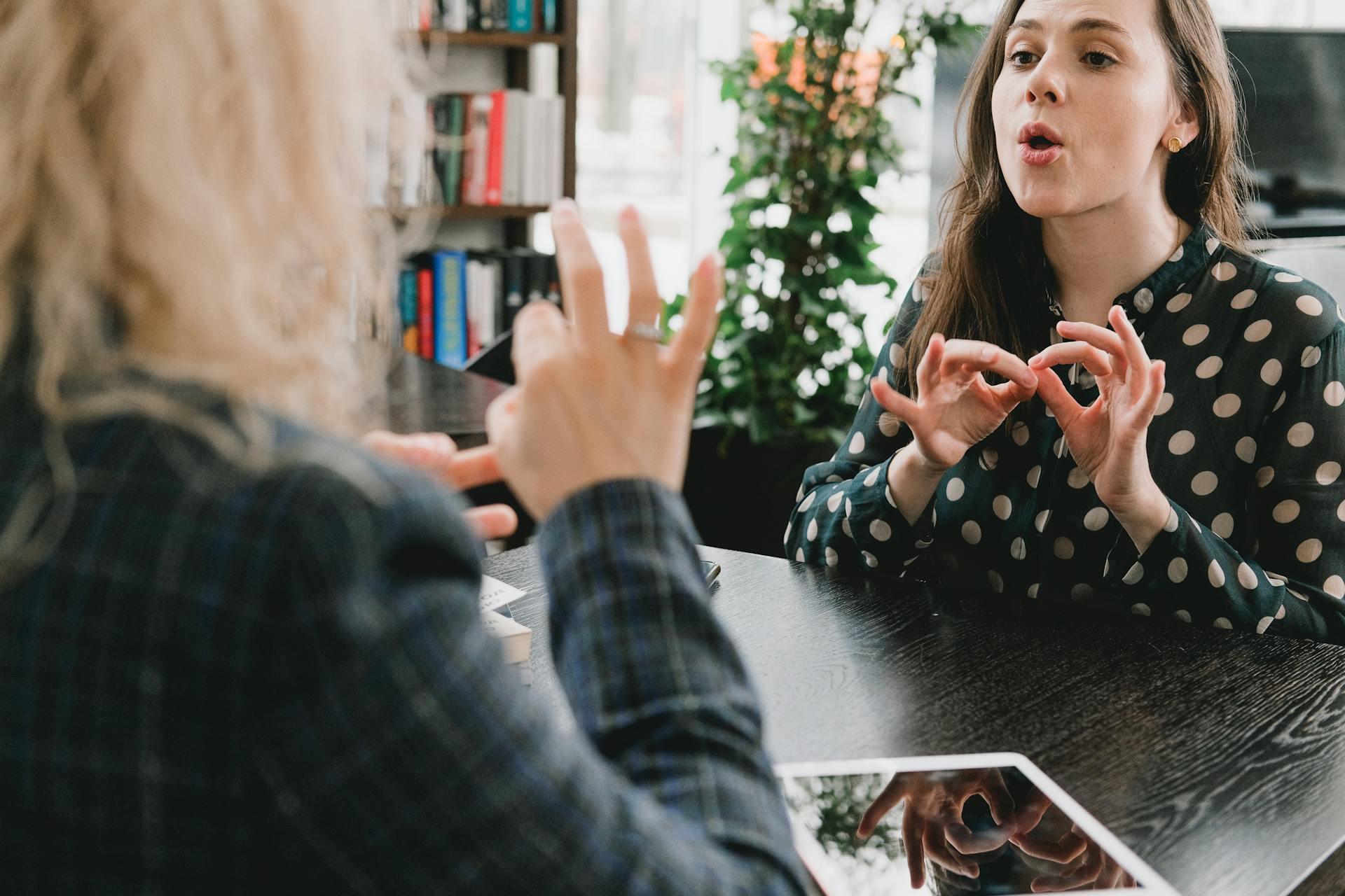 Two women talking in sign language.