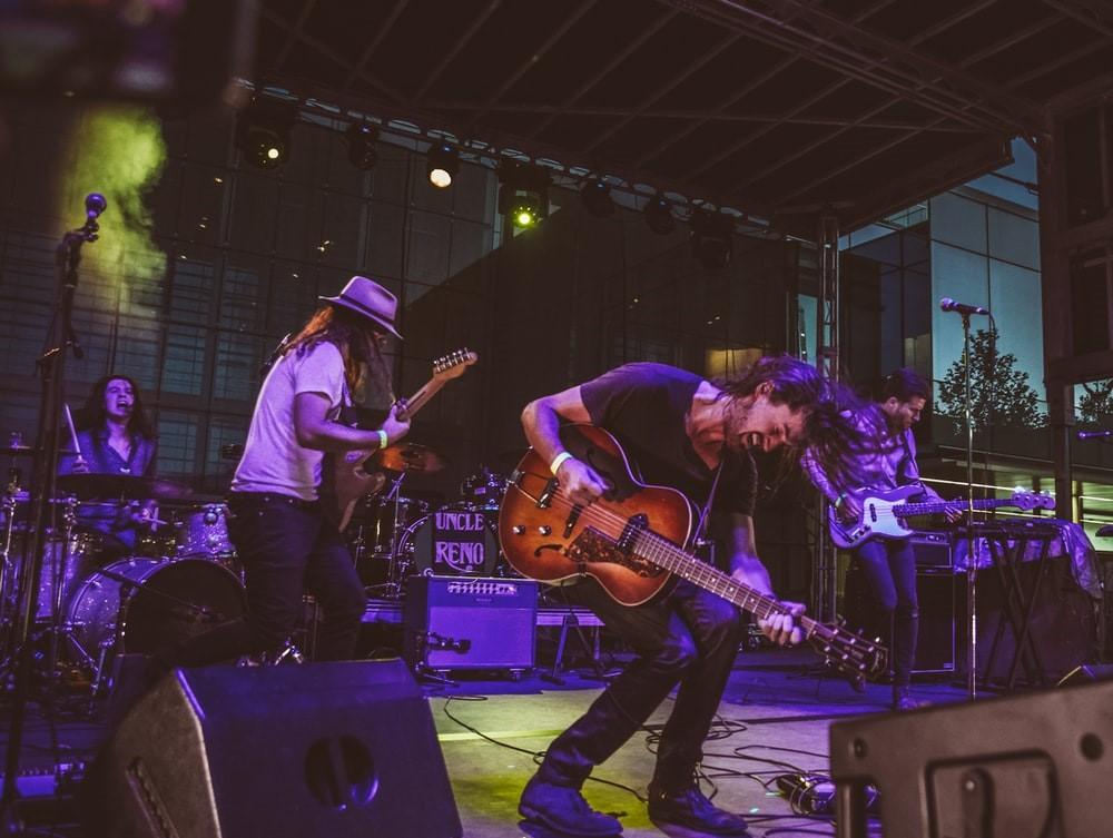 A band playing rock guitar in a concert