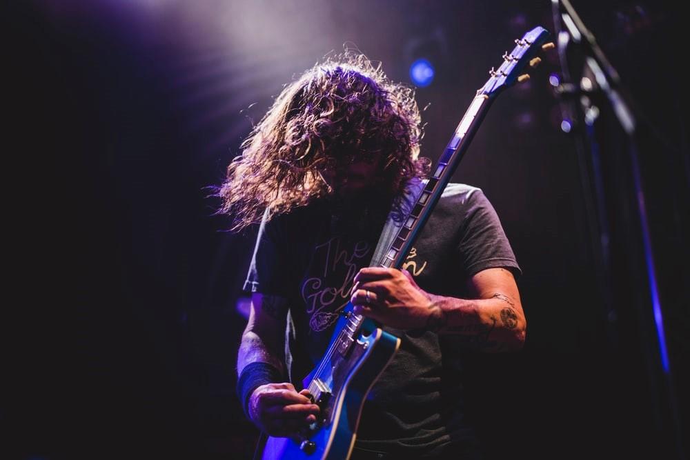 A rockstar playing a rock guitar on stage