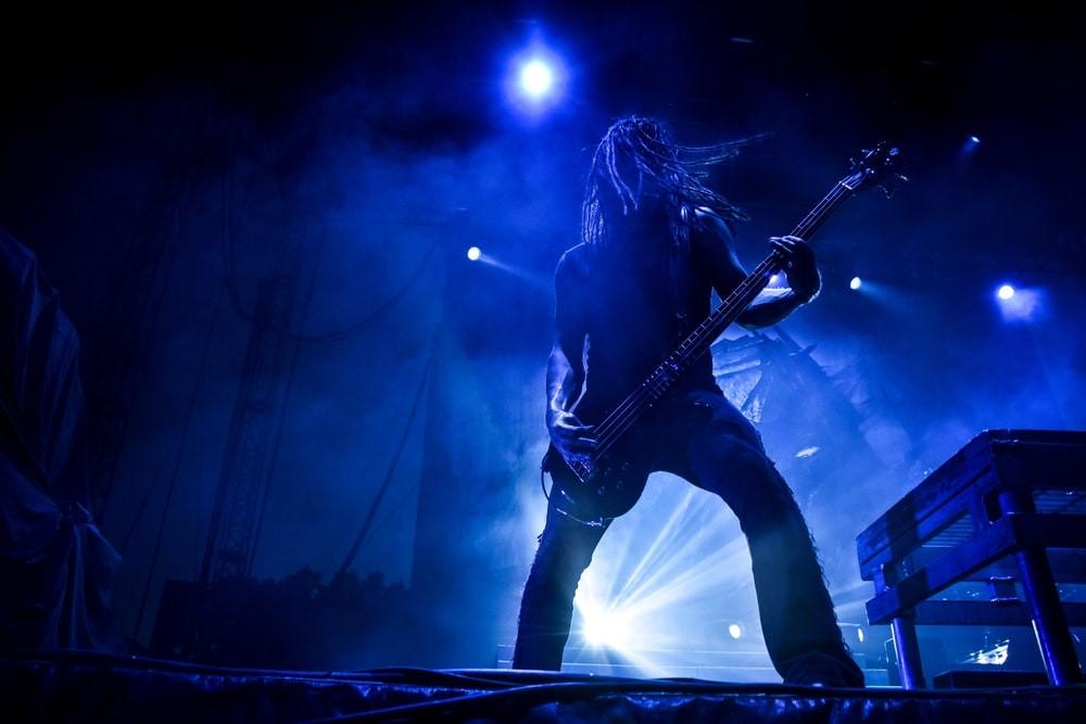 A guitarist performing on the stage under the neon light