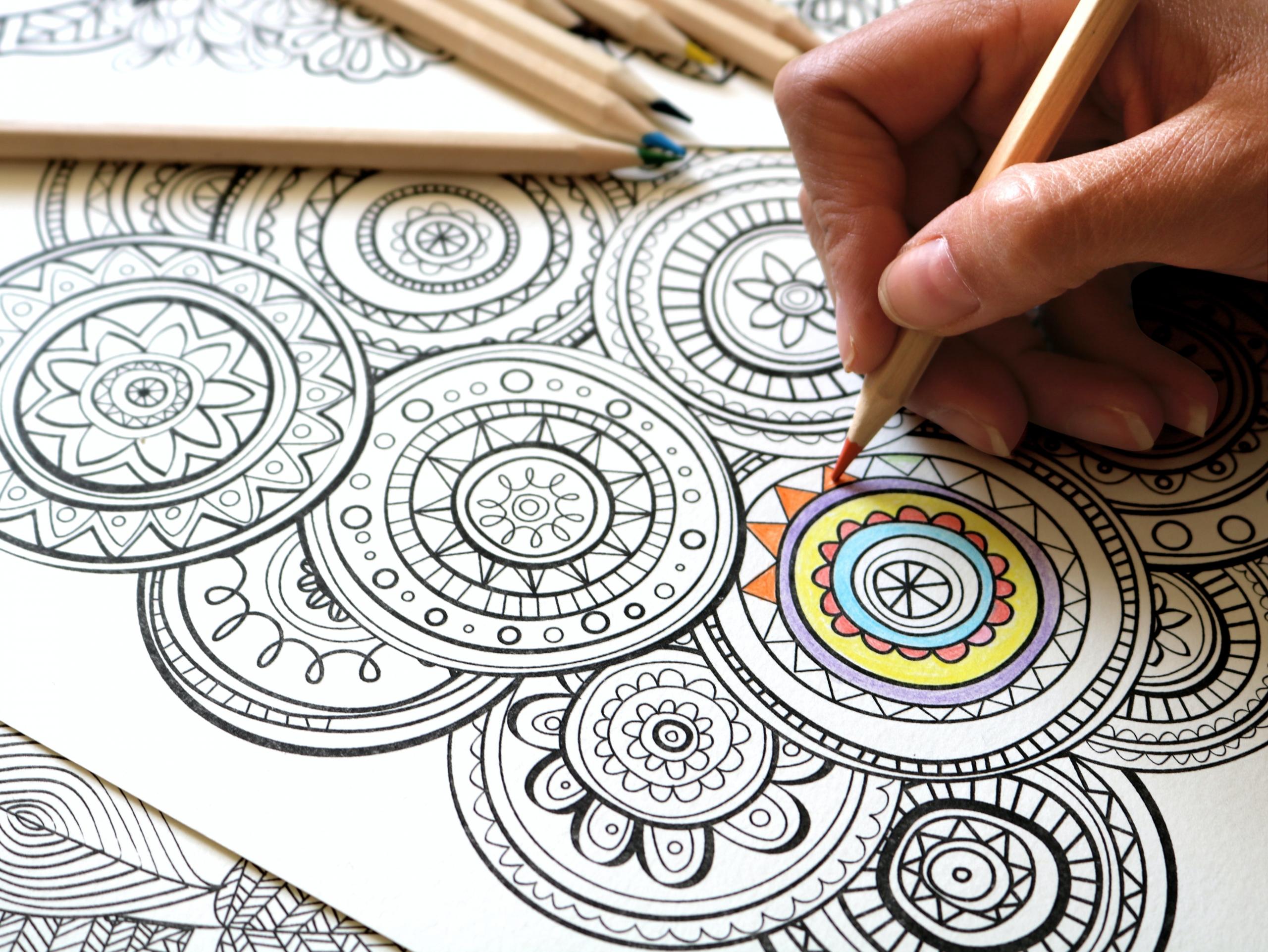 An artist coloring in mandala doodles