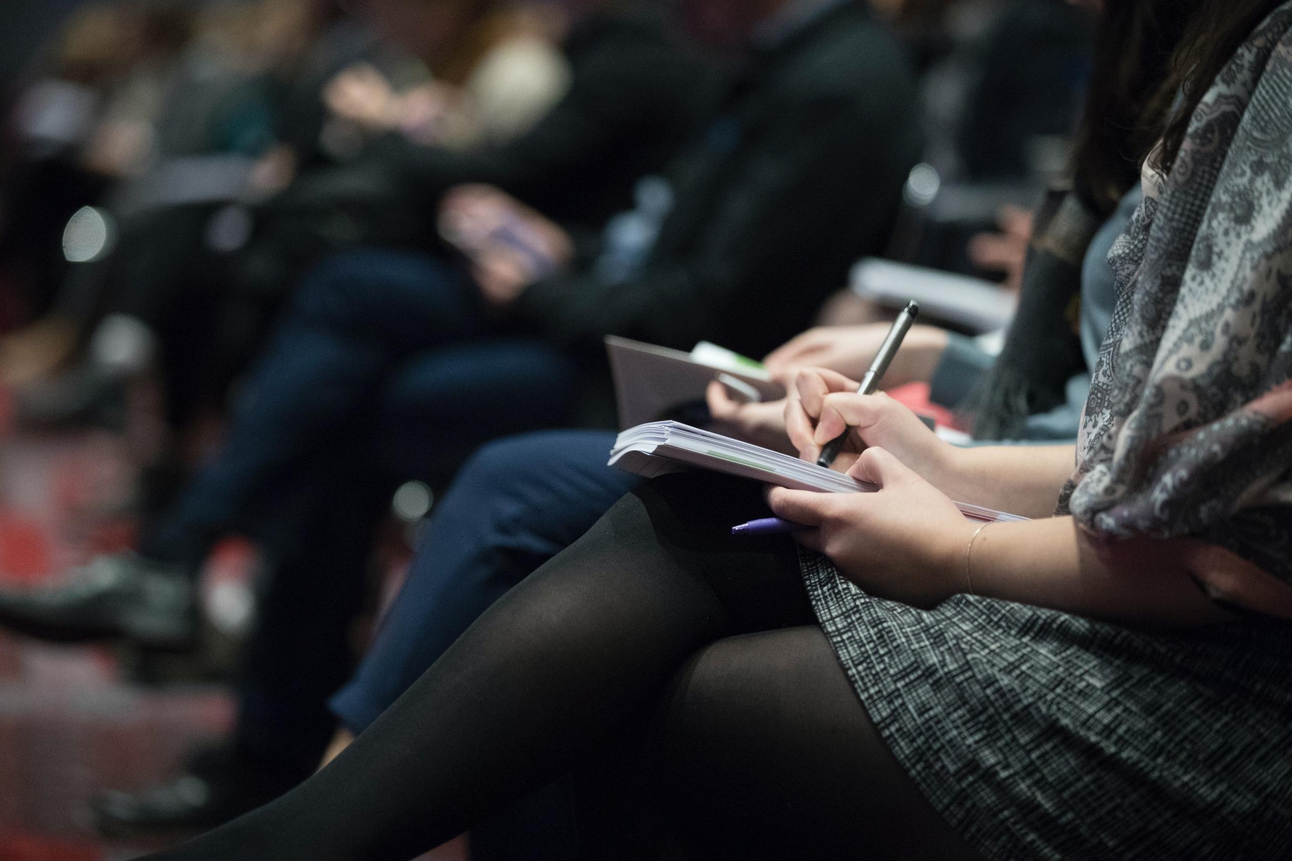 Selective focus photography of a woman writing in a notebook during a training session