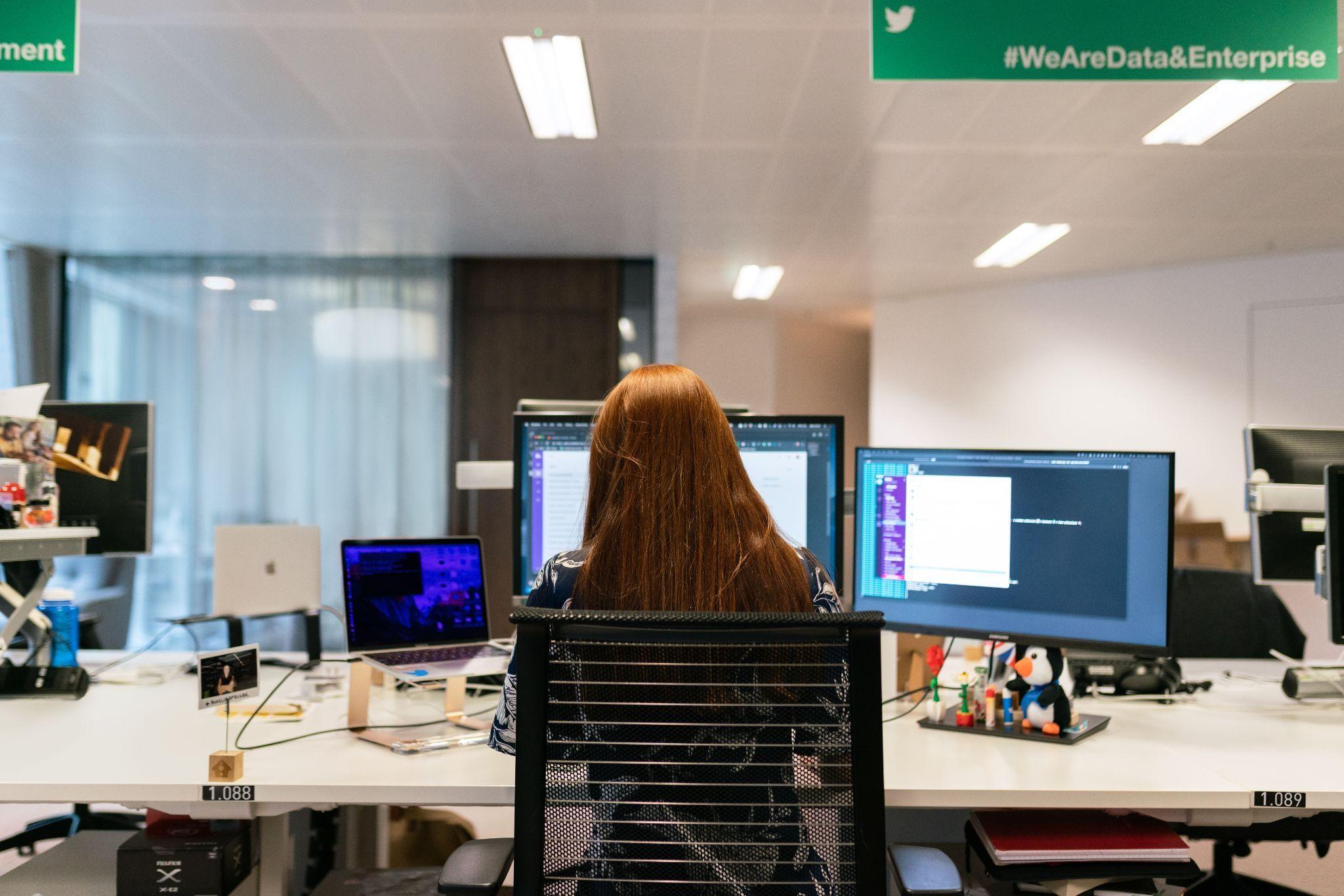 Woman in black shirt sitting in a chair in front of a computer