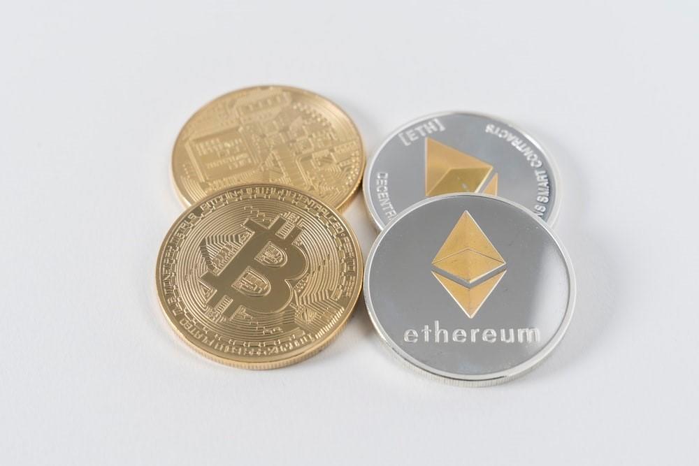 Four round silver and golden coins illustrating cryptocurrencies