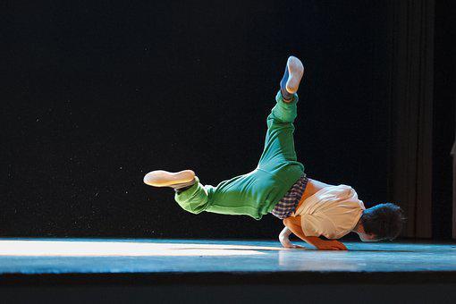 Boy dancing on the stage and showing dancing moves to entertain the audience