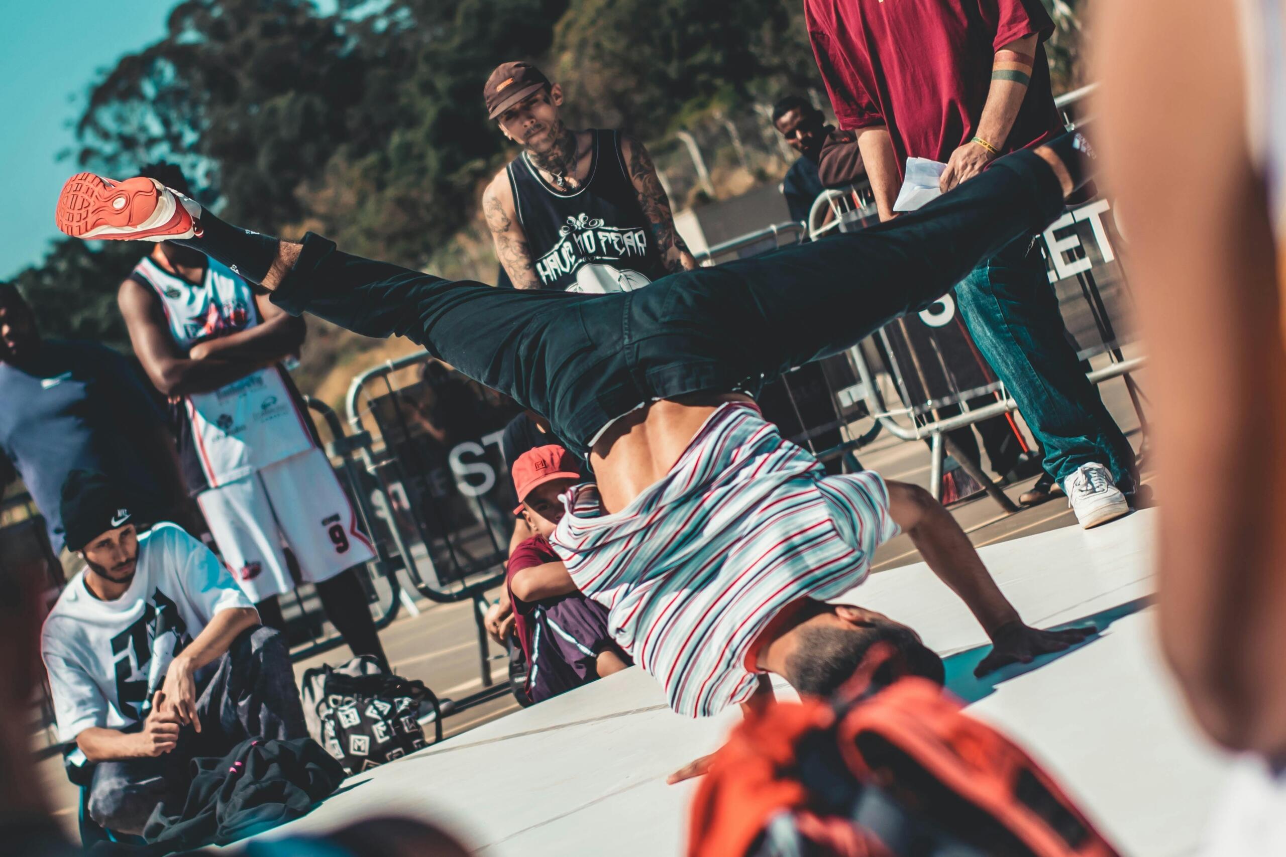 A man performing a headstand as part of a breakdancing routine.