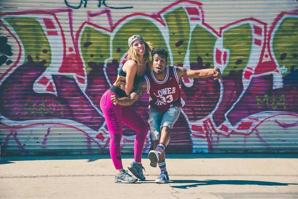 Graffiti wall in the background as two dancers pose