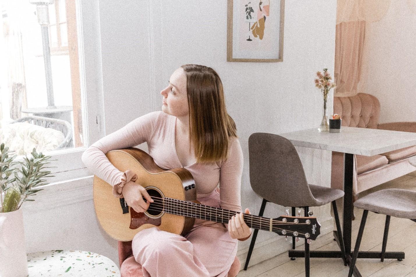 A girl playing an acoustic guitar