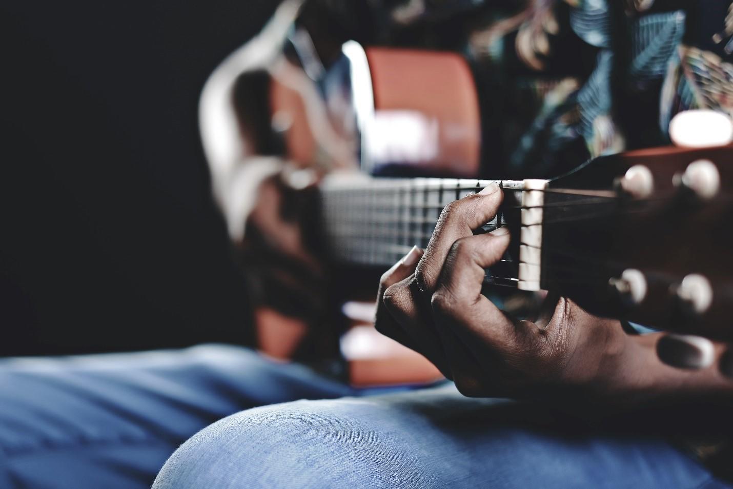 A close-up of a man playing an acoustic guitar