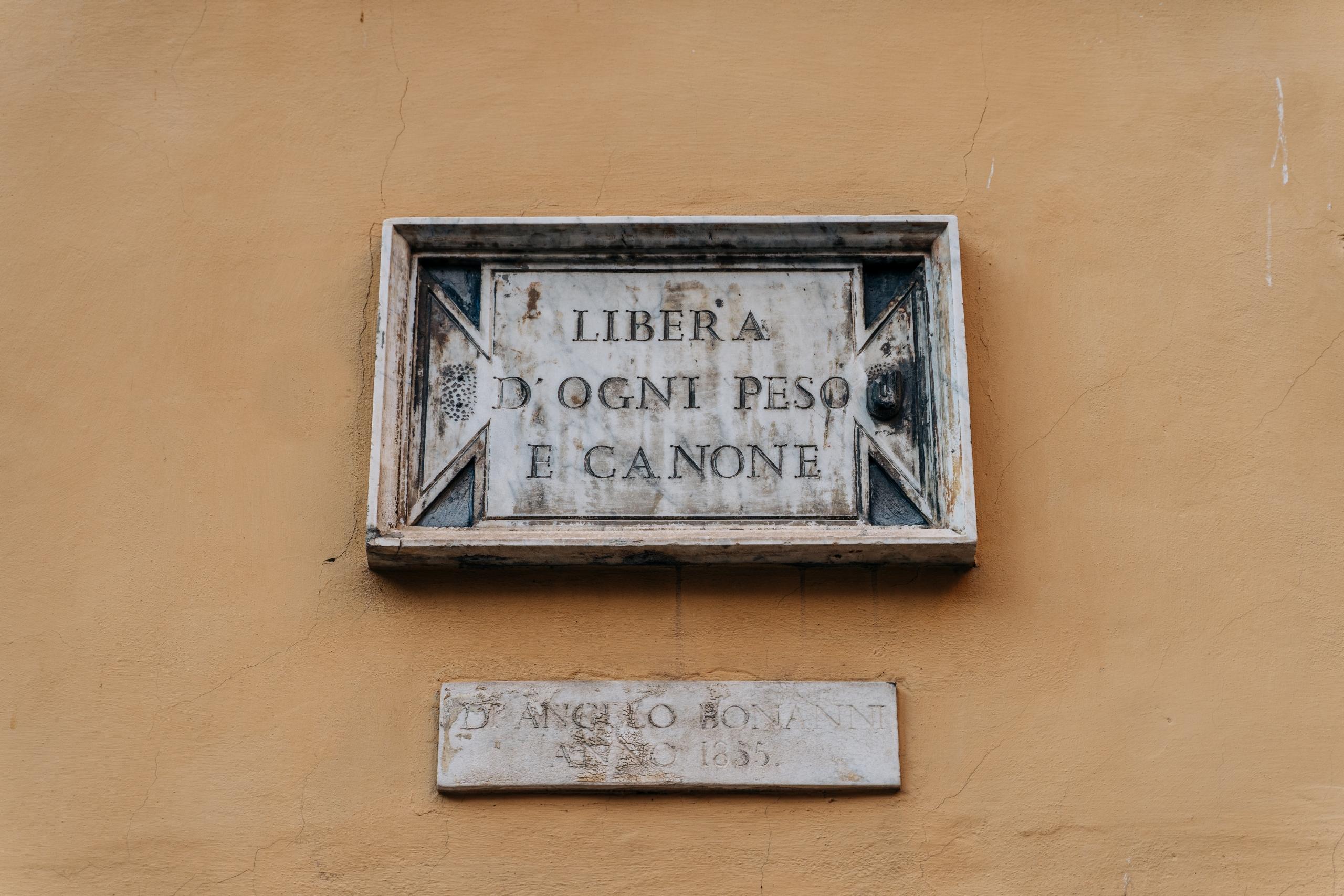 A sign on the building entrance saying in the Italian language that "Free from Debt or Mortgage"