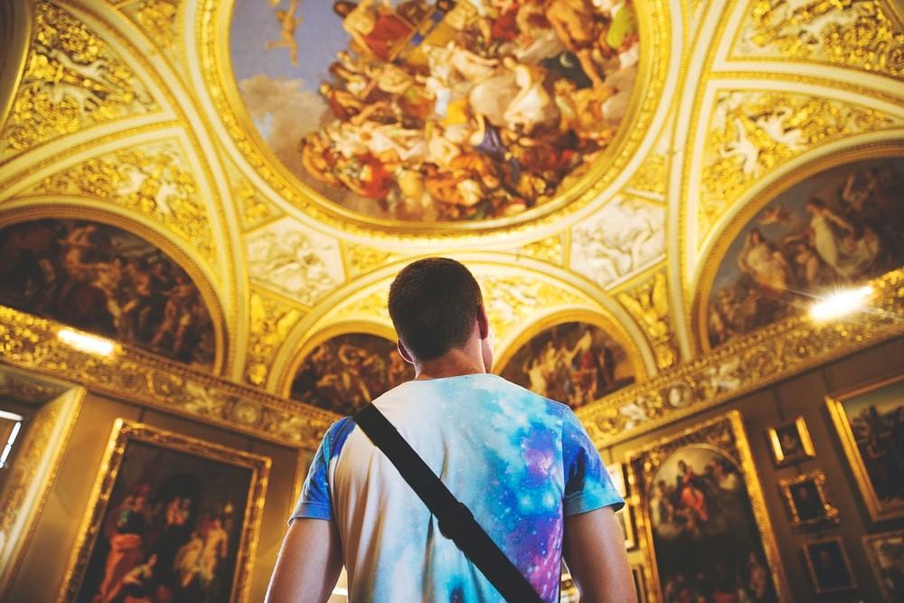 A man gazing toward a gold ceiling