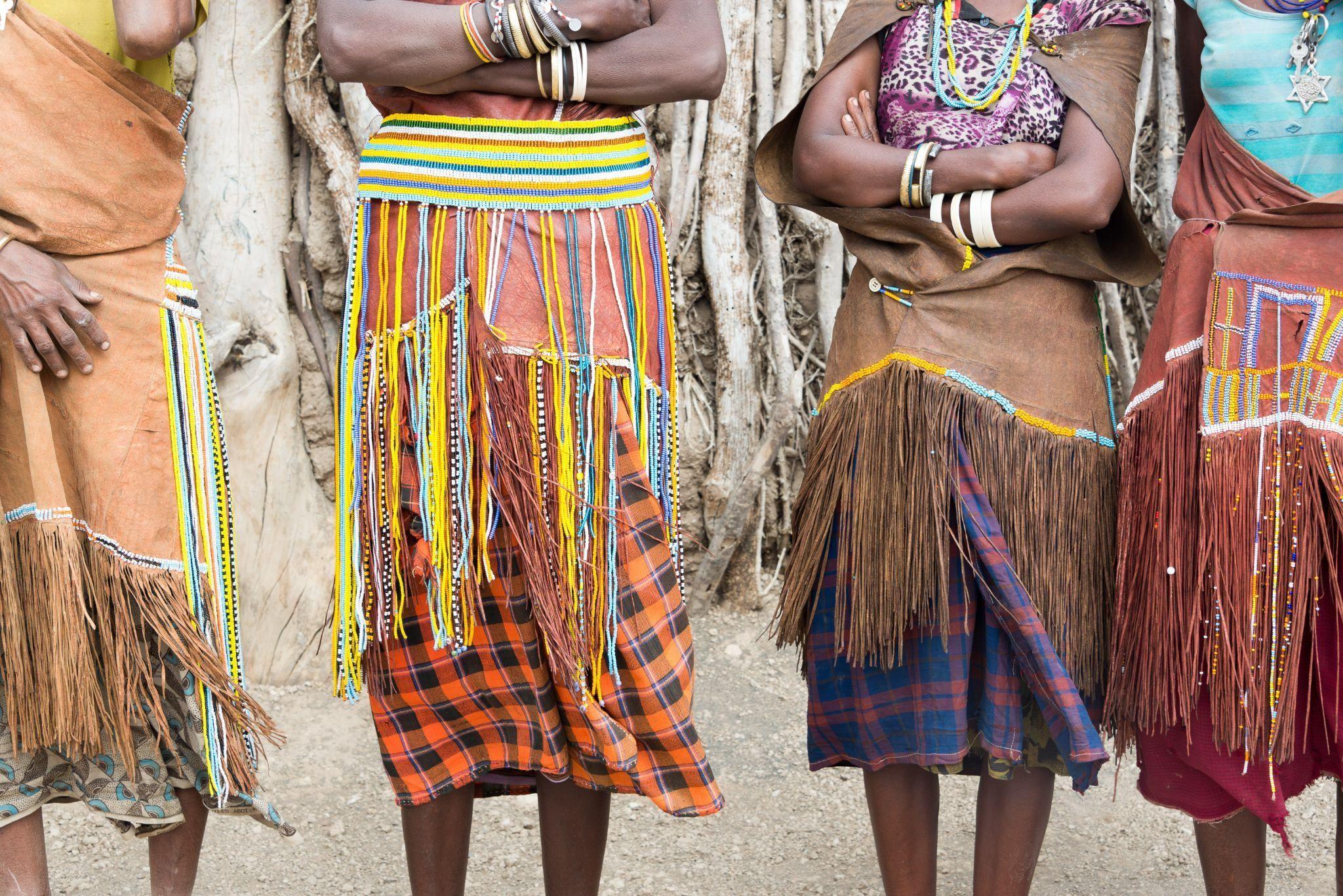The lower half of tribal African people adorned with colorful clothes