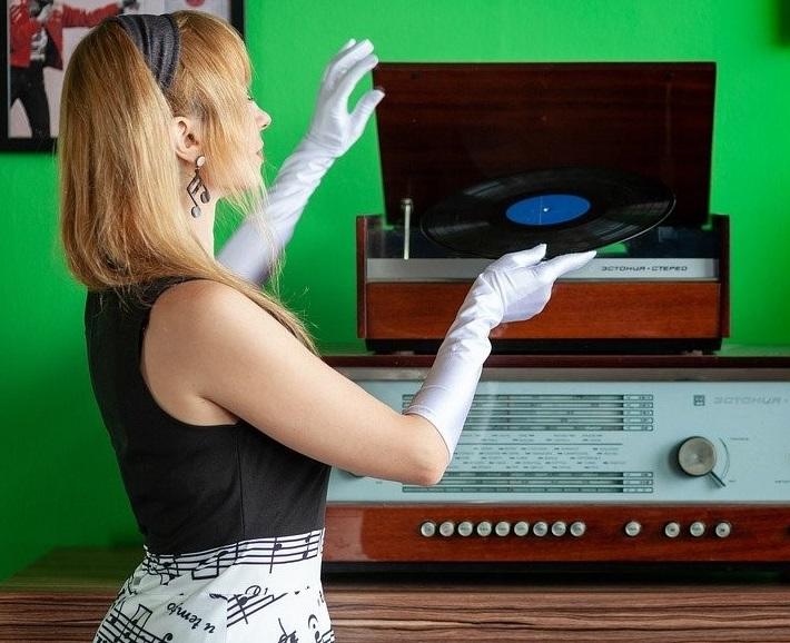 A woman inserting a disc full of soulful songs into a recorder