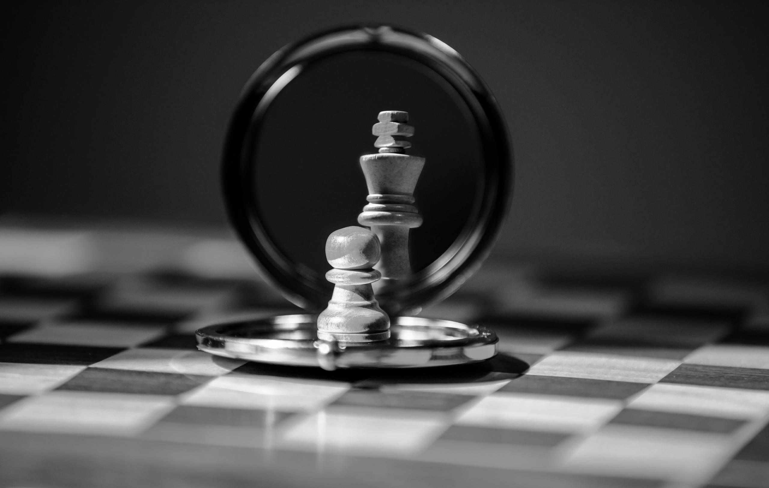 A close-up shot of a pawn chess piece in front of a mirror