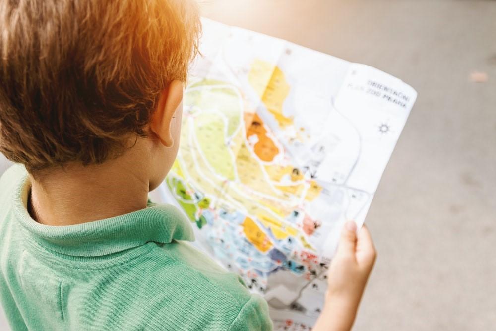 A small boy looking at a map's picture