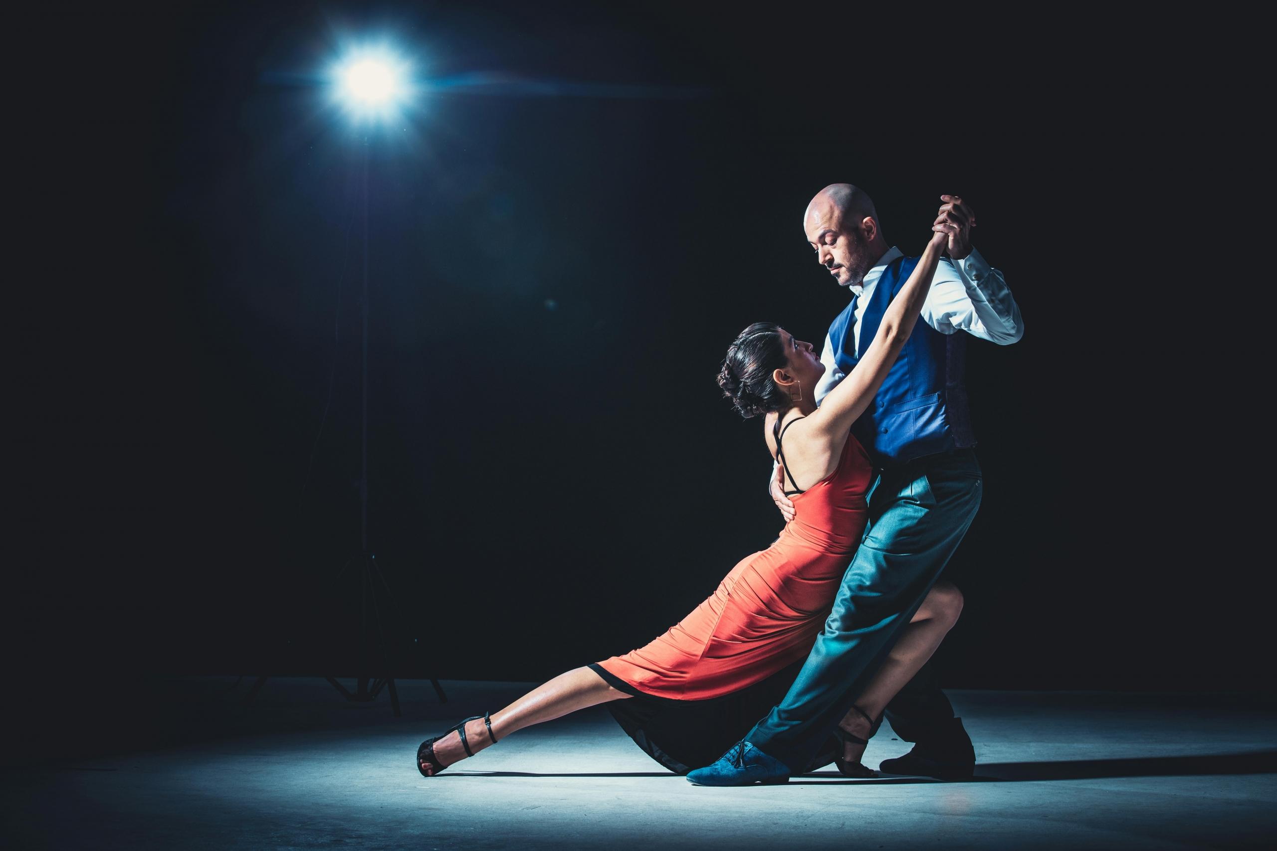 A man and woman dancing salsa together in a synchronized and energetic performance.