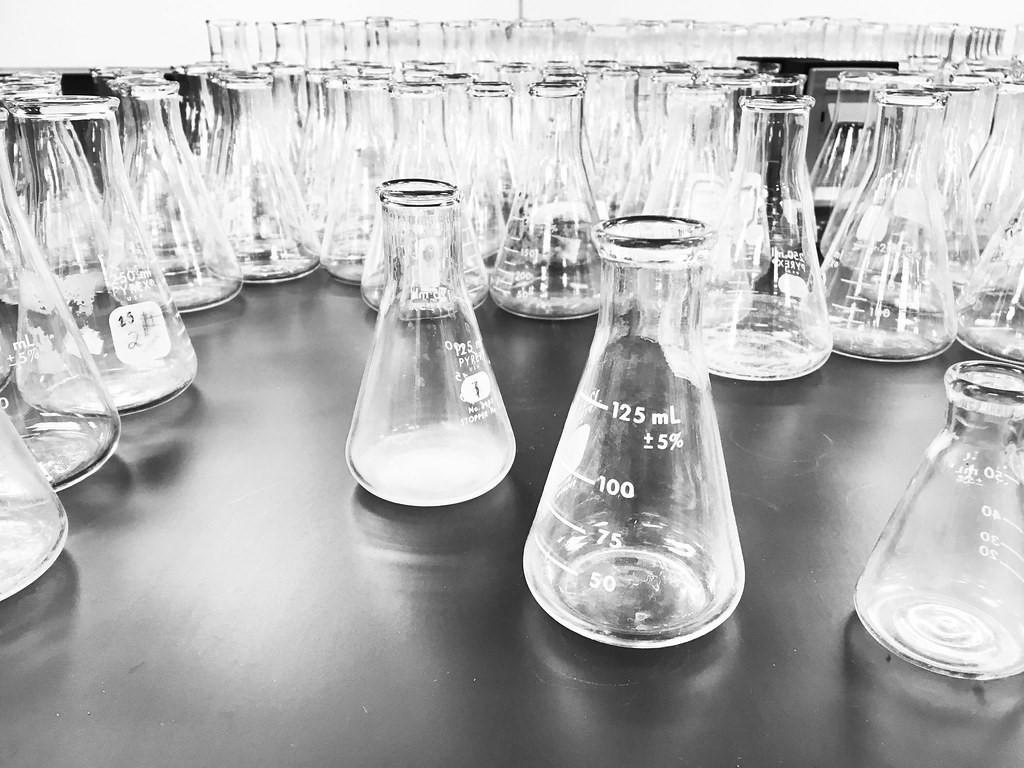 Clear transparent flasks on a wooden table in a laboratory