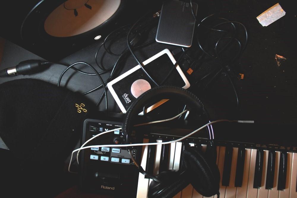 Musical equipment lying on a black table with a beanie on the side