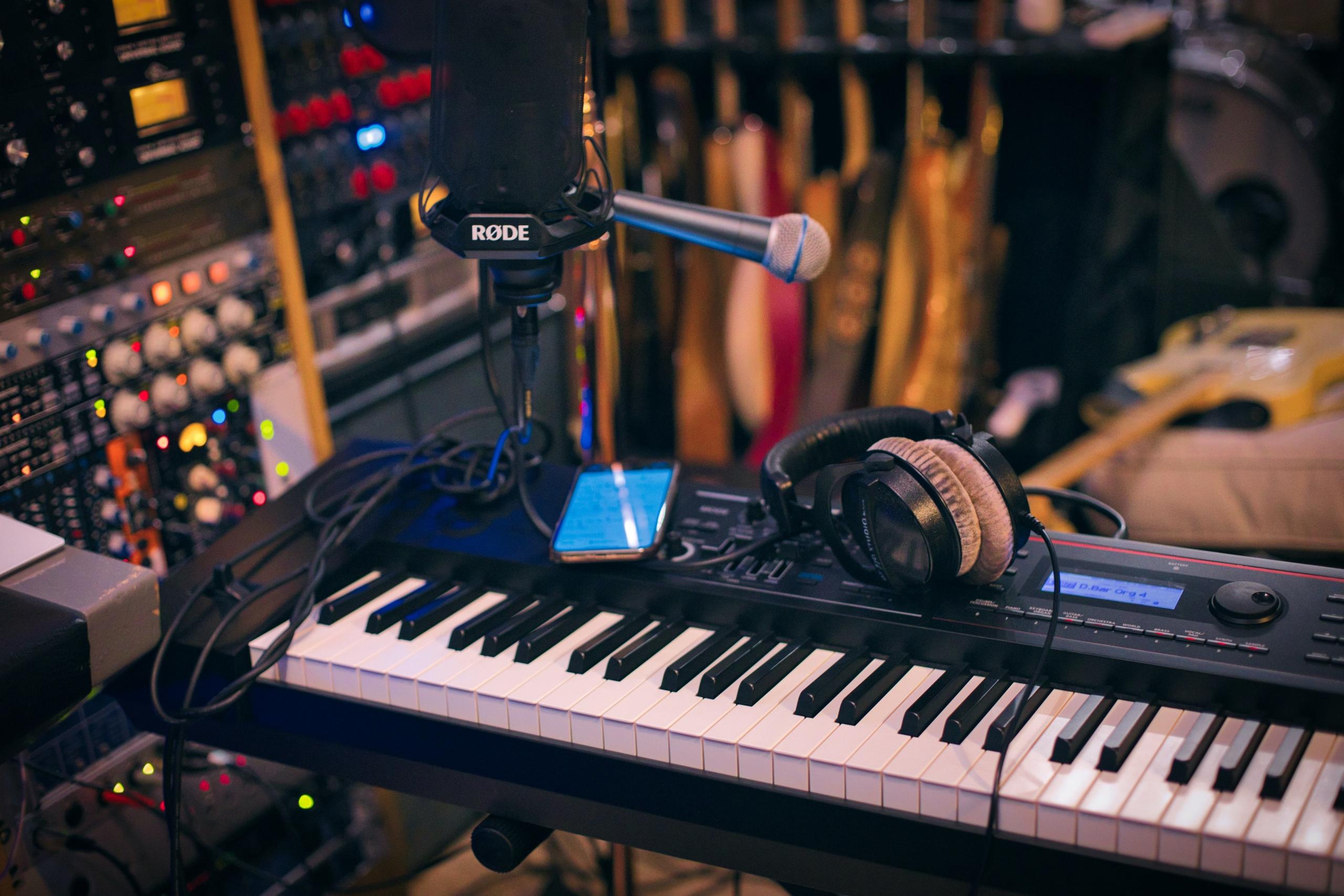 : A piano, microphone, and headphones in a recording studio