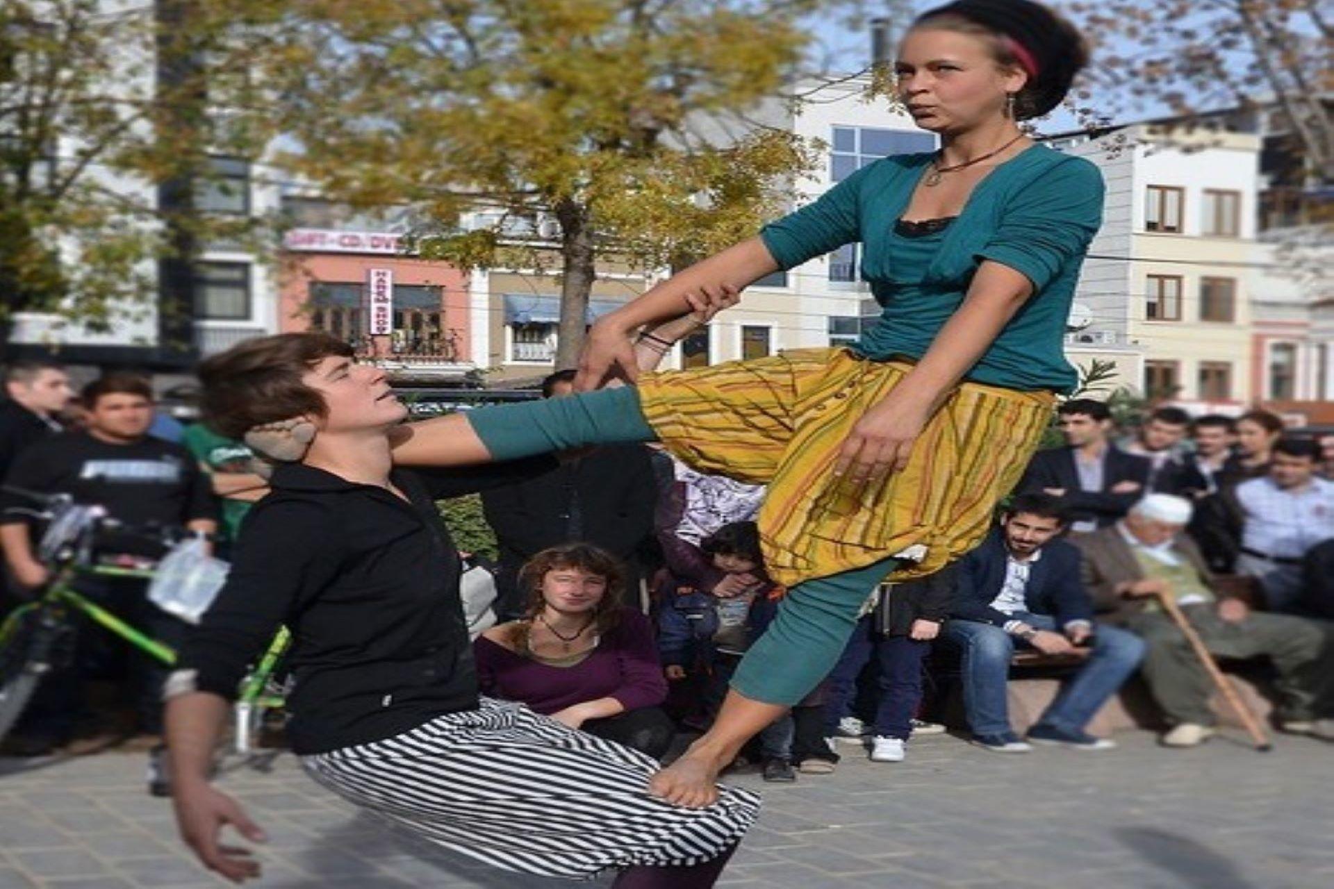Two people performing AcroYoga on the street.