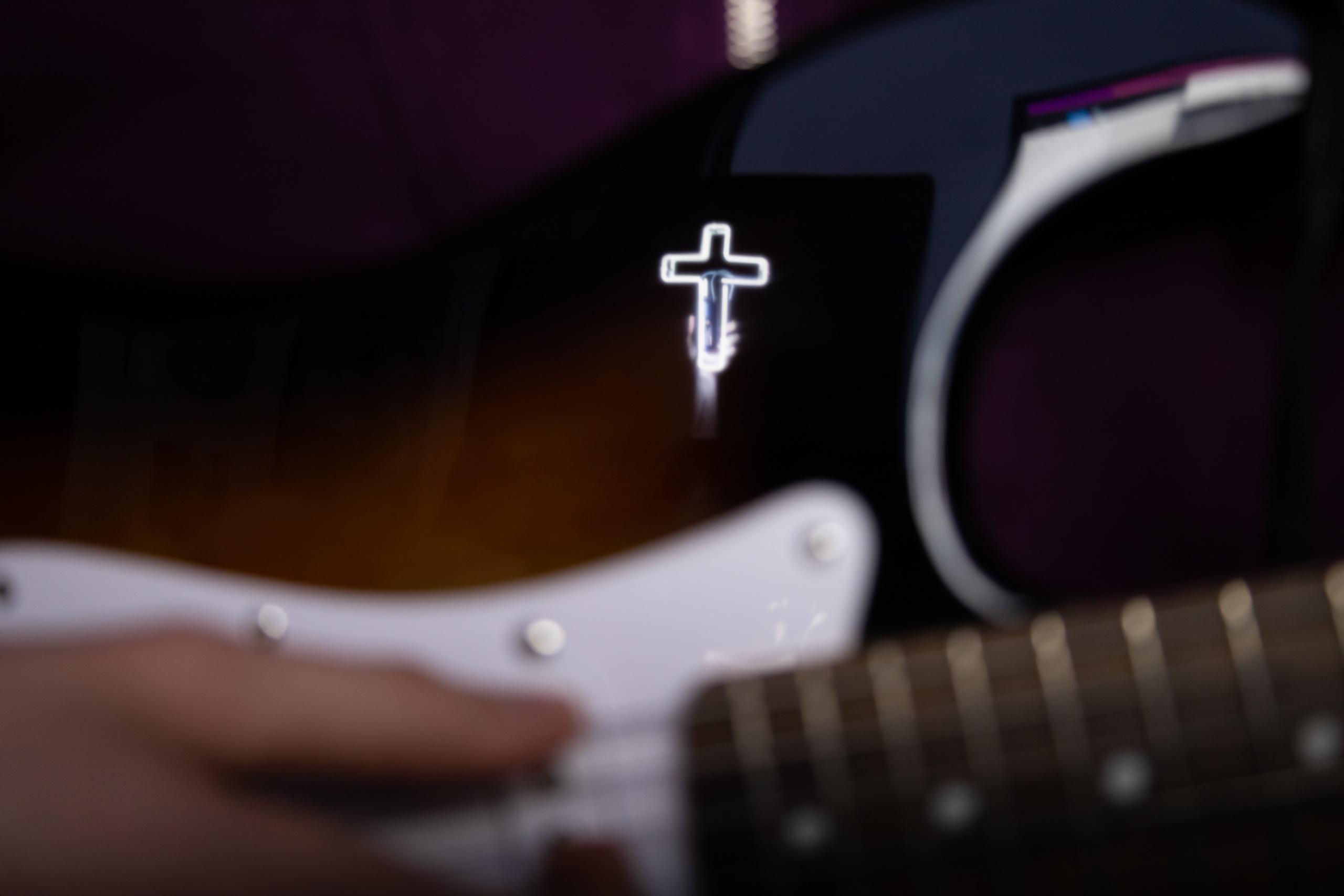 A contemporary gospel singer playing an electronic guitar