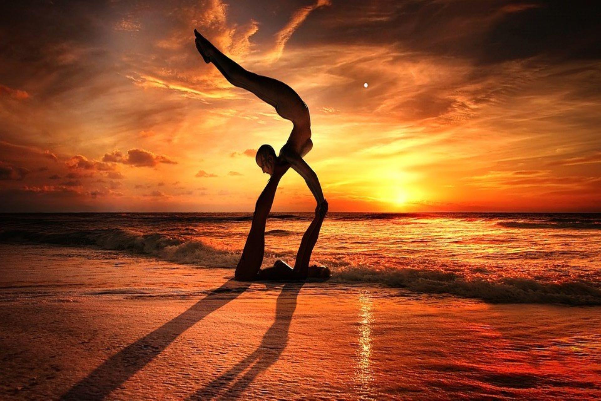 Practicing AcroYoga at the beach