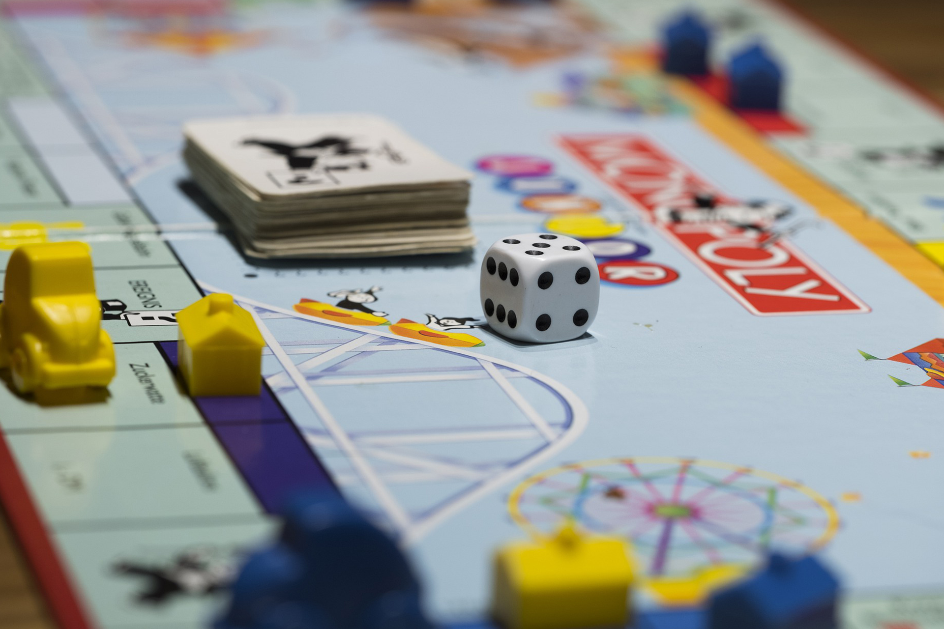 Monopoly board game with dice, cards, and yellow houses