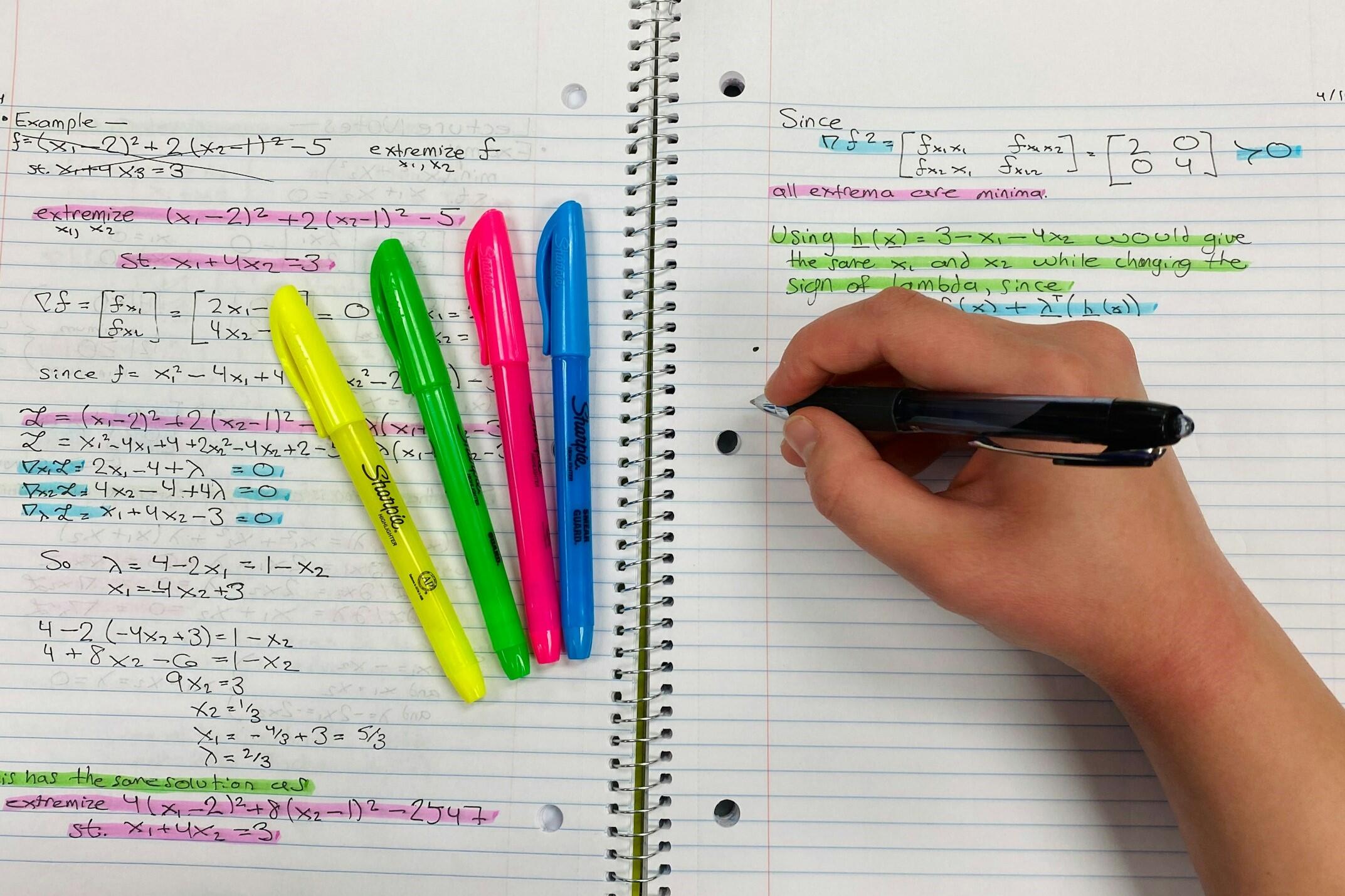 Hand writing mathematical equations in a notebook