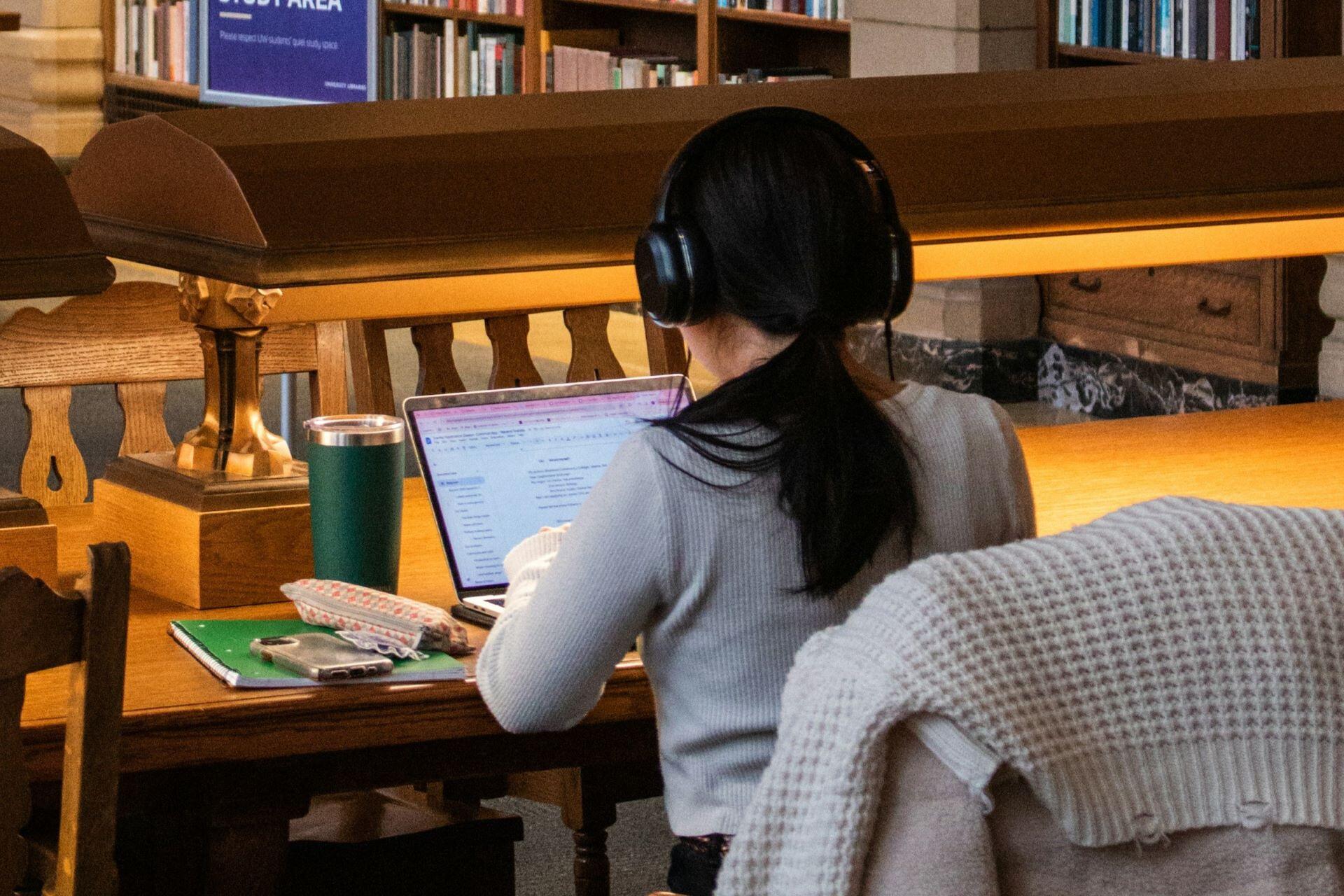 Student studying on a laptop in a university library
