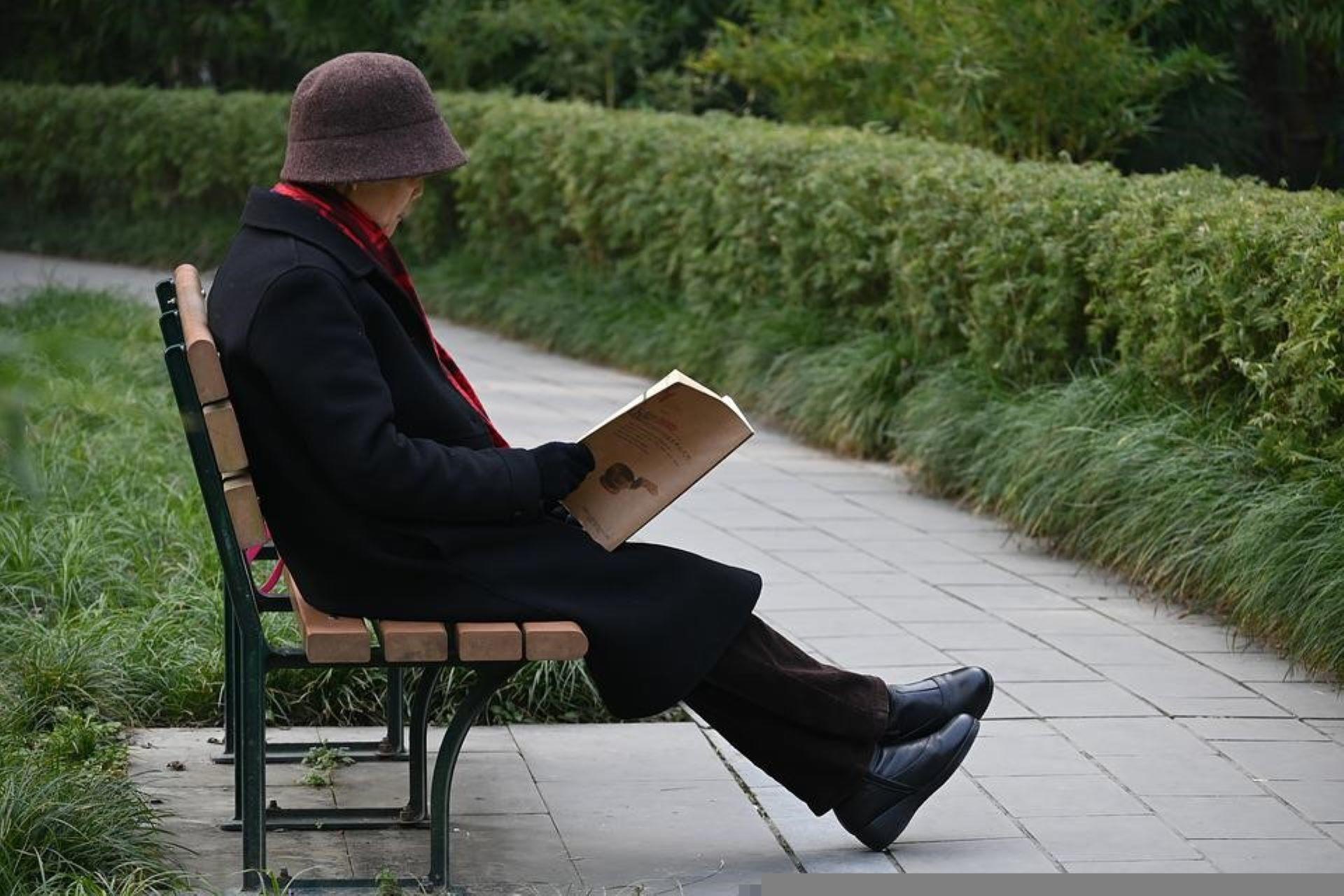 A lady reading a book in a park