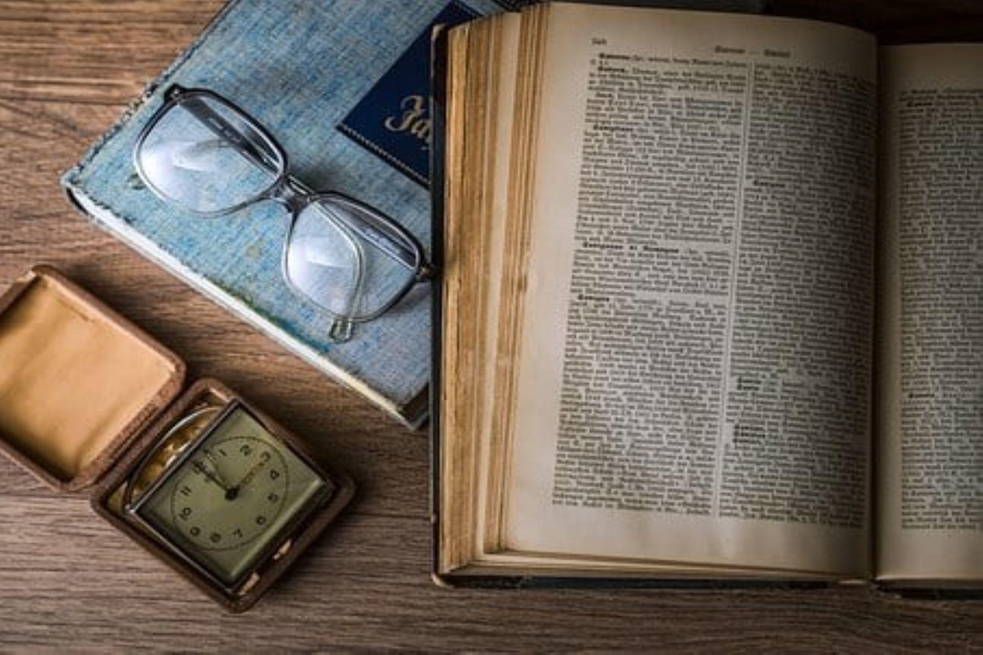 A book, a pocket watch, and a pair of spectacles.