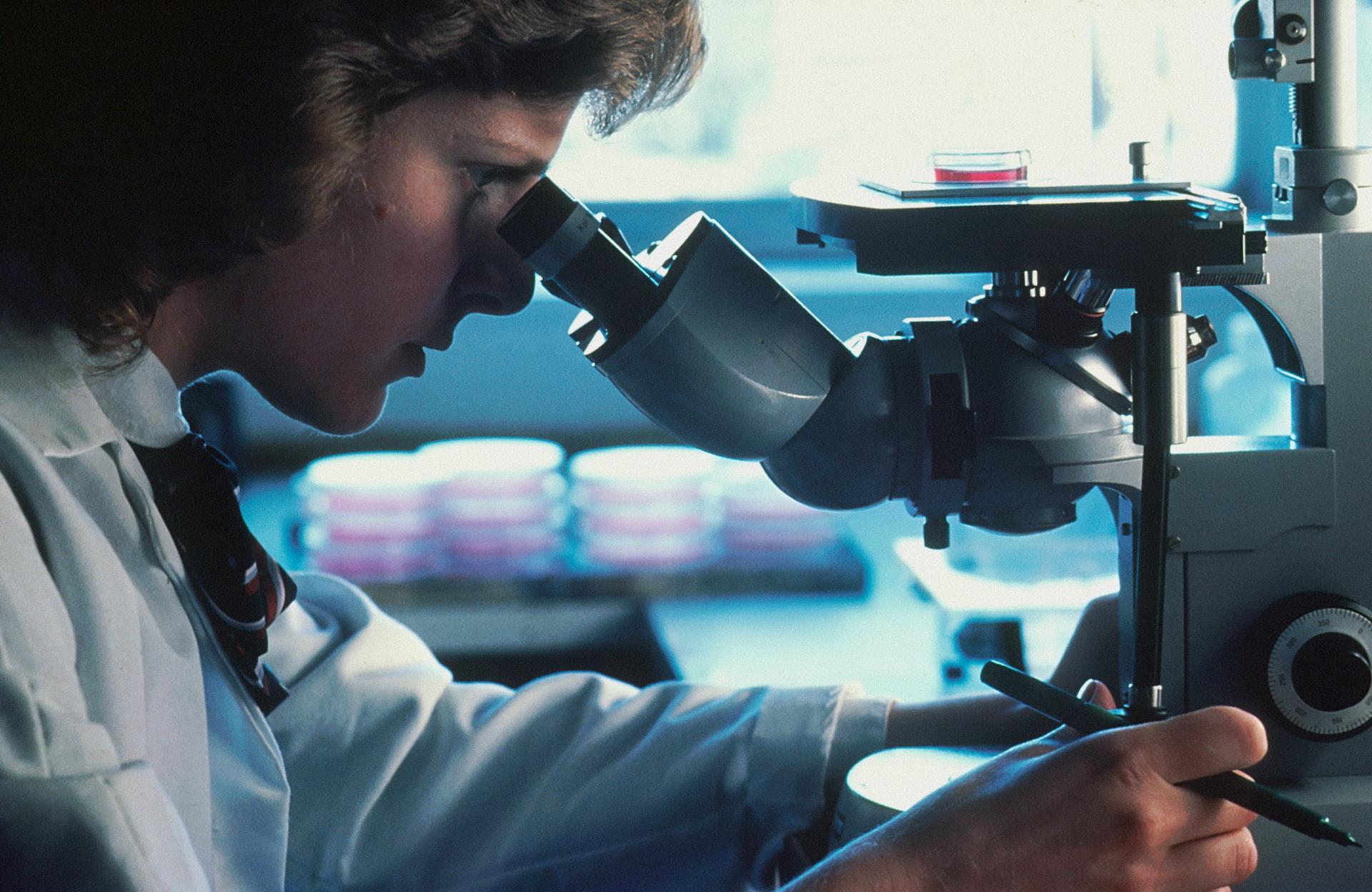 Researcher looking into a microscope