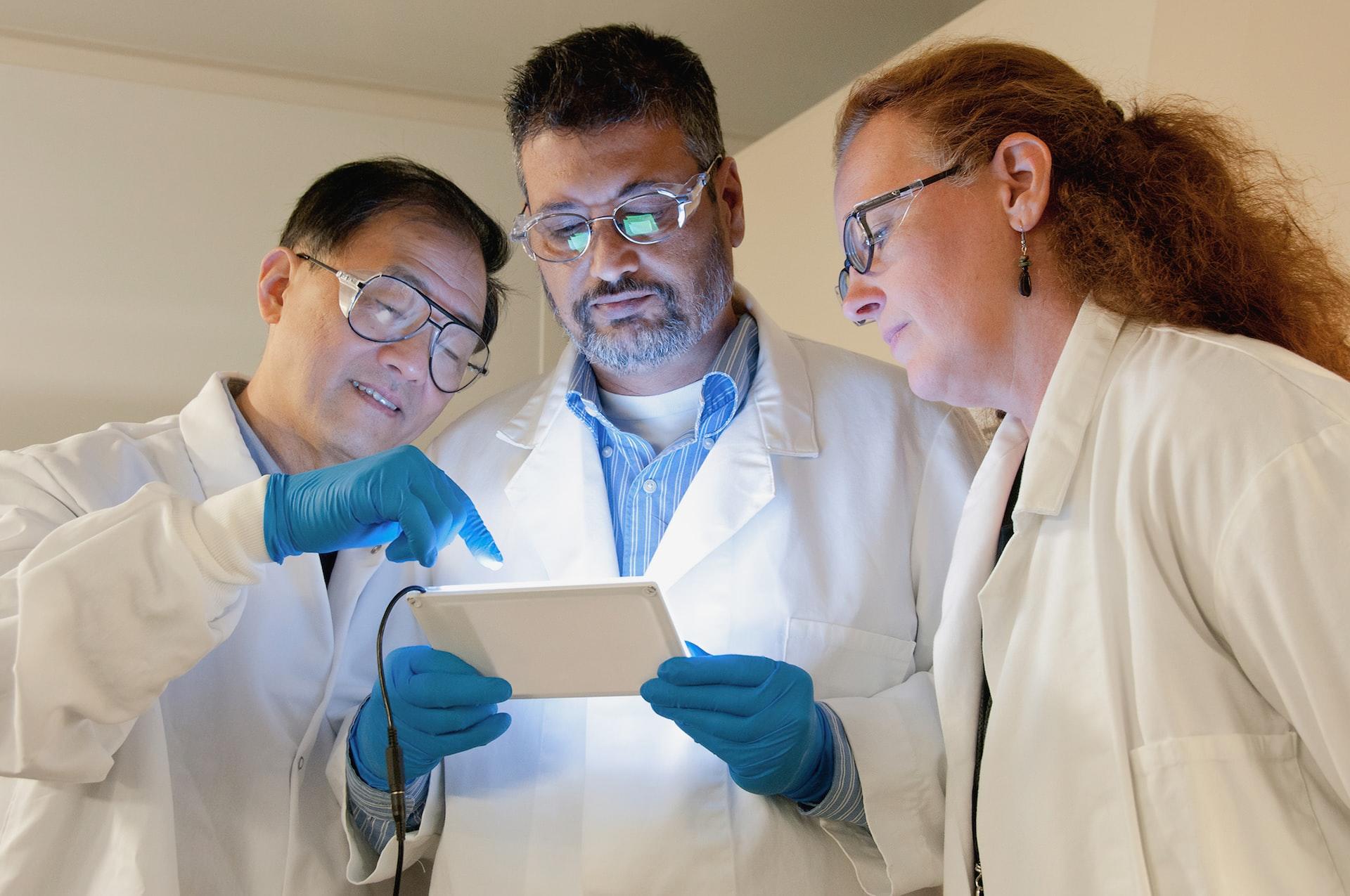 Scientists huddled around a device