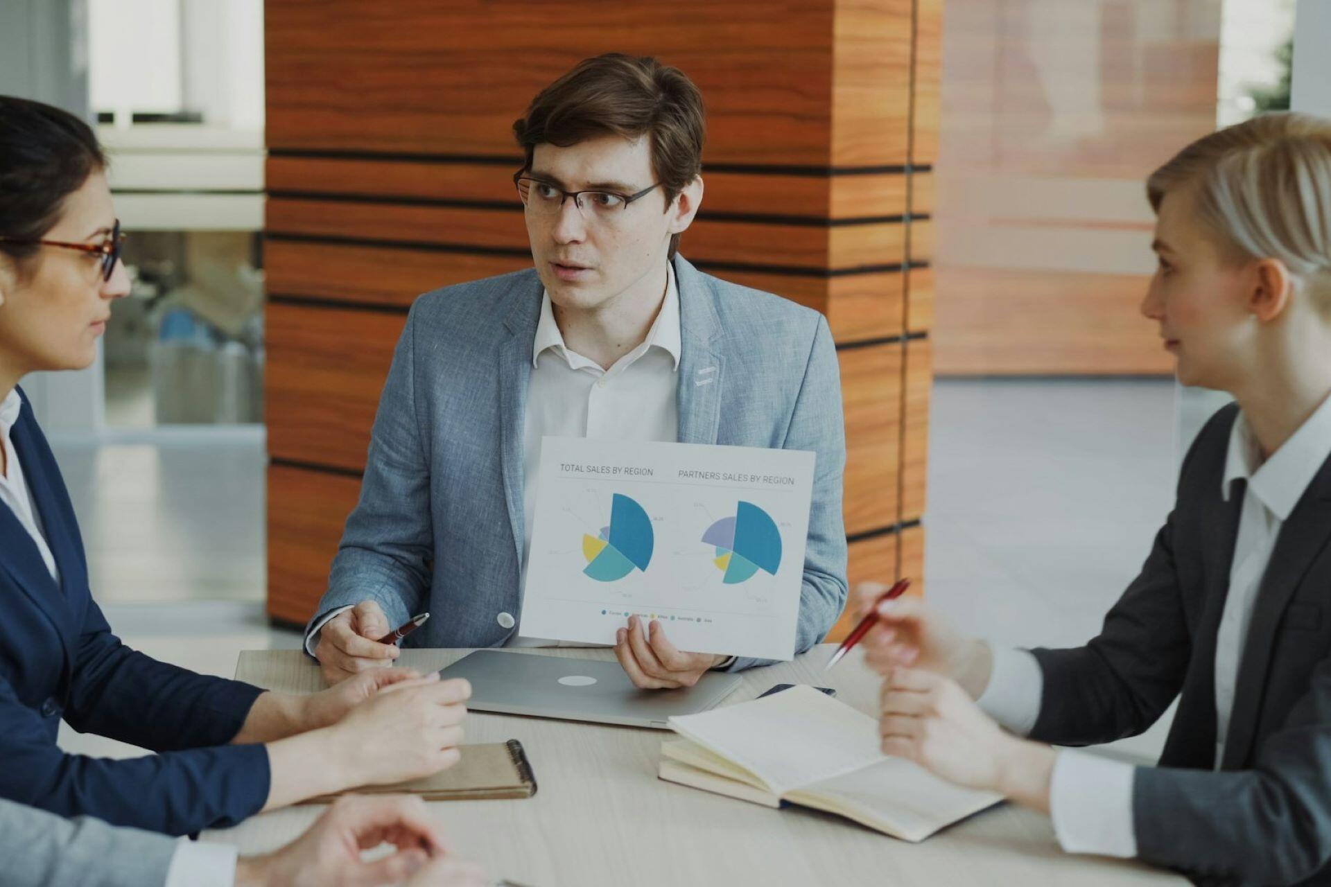 Professional presenting data charts to colleagues during a meeting