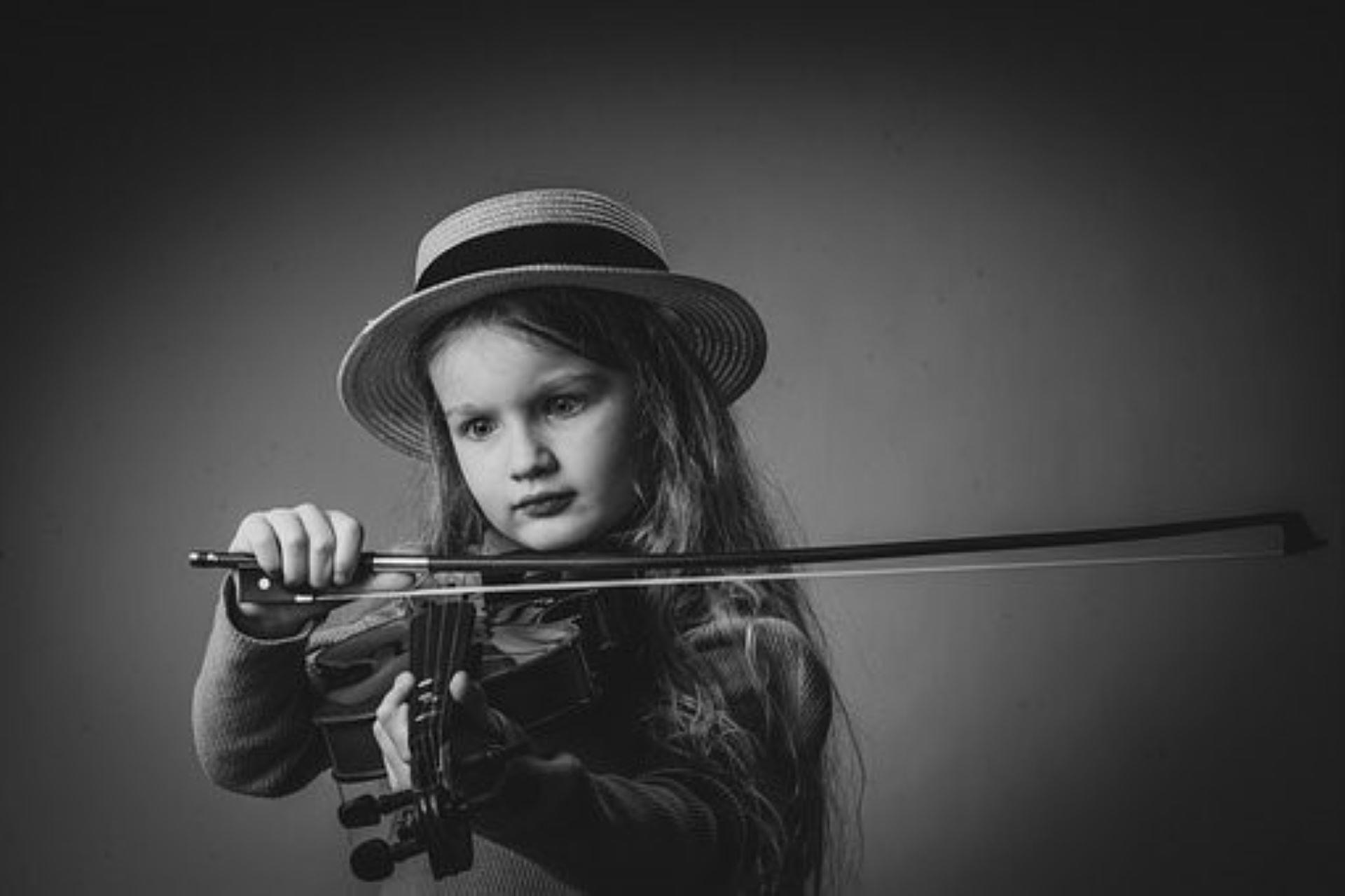 A little girl playing the violin.