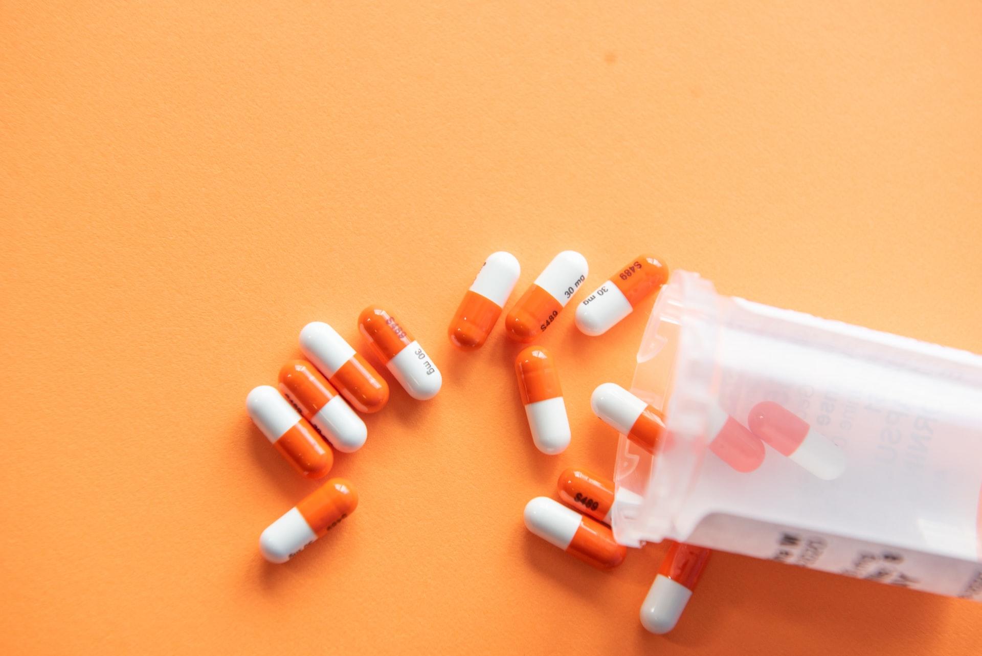 Bottle of pills on orange background