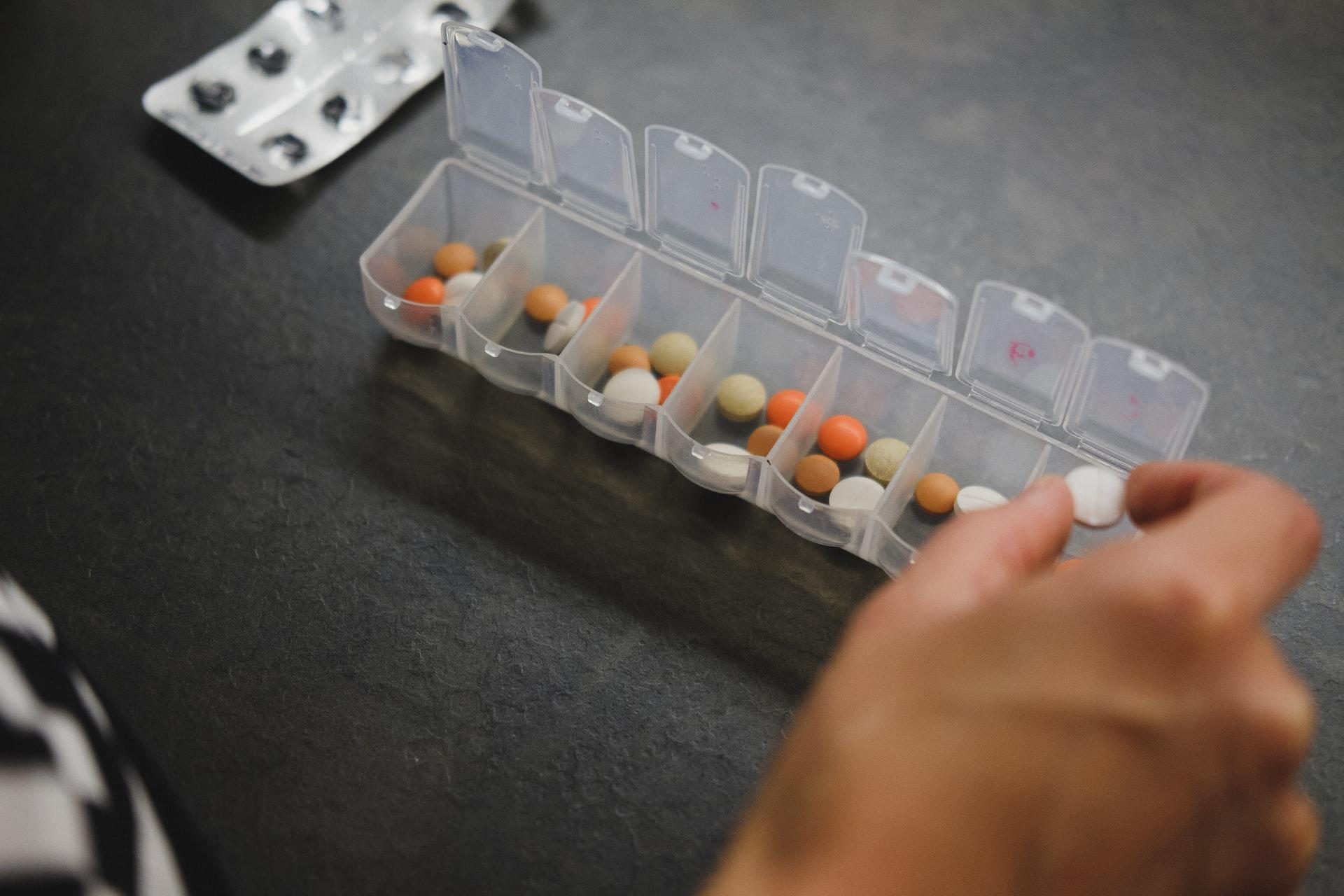 Person placing medication into pill holder