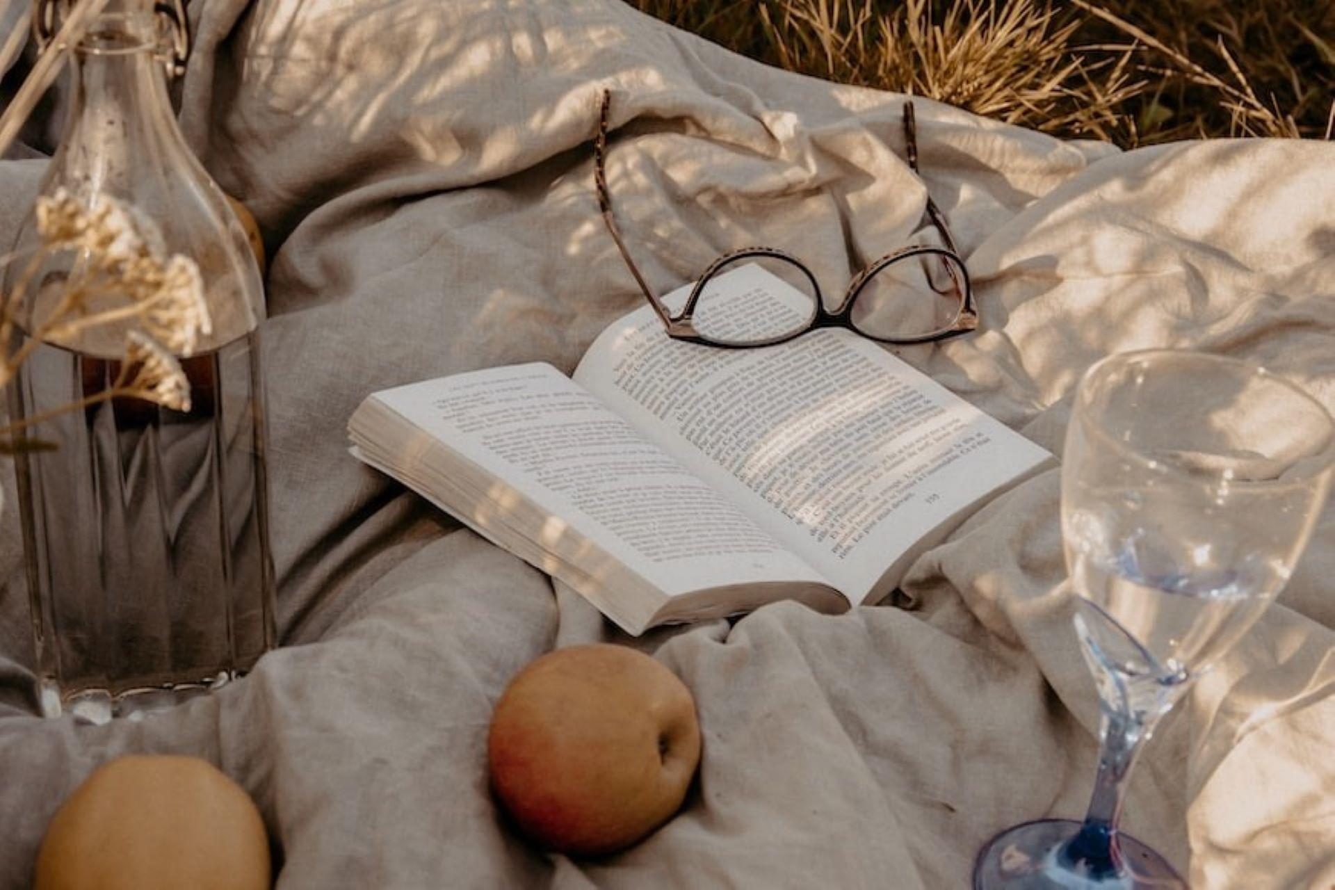 A poetry book with glasses and a glass of water