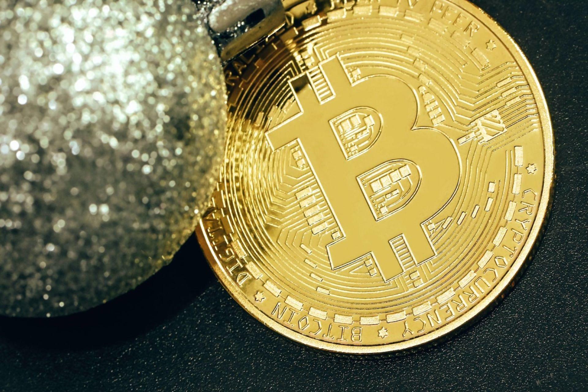 A Bitcoin placed next to a silver glitter ball