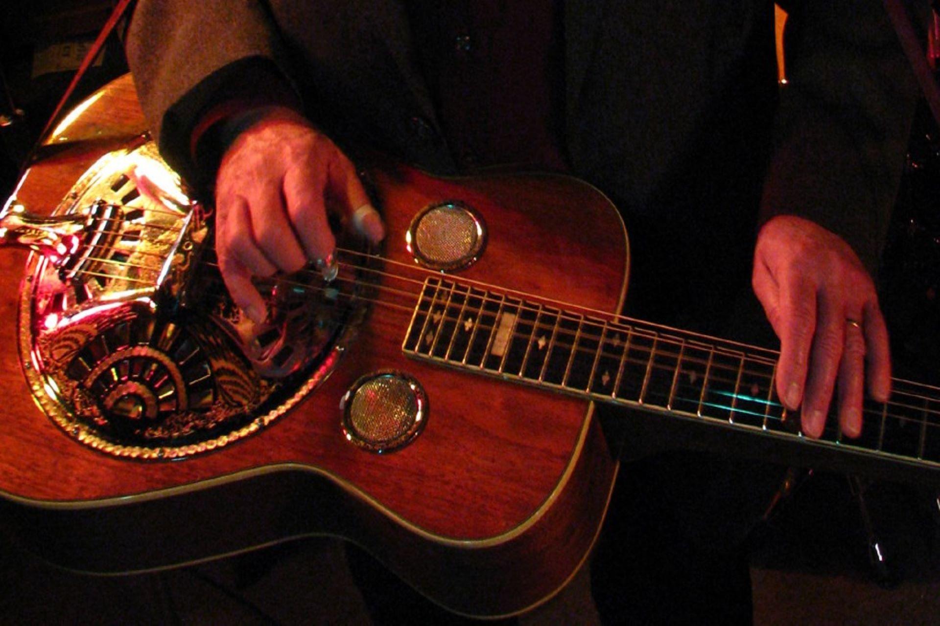 A musician playing resonator in the lap style.