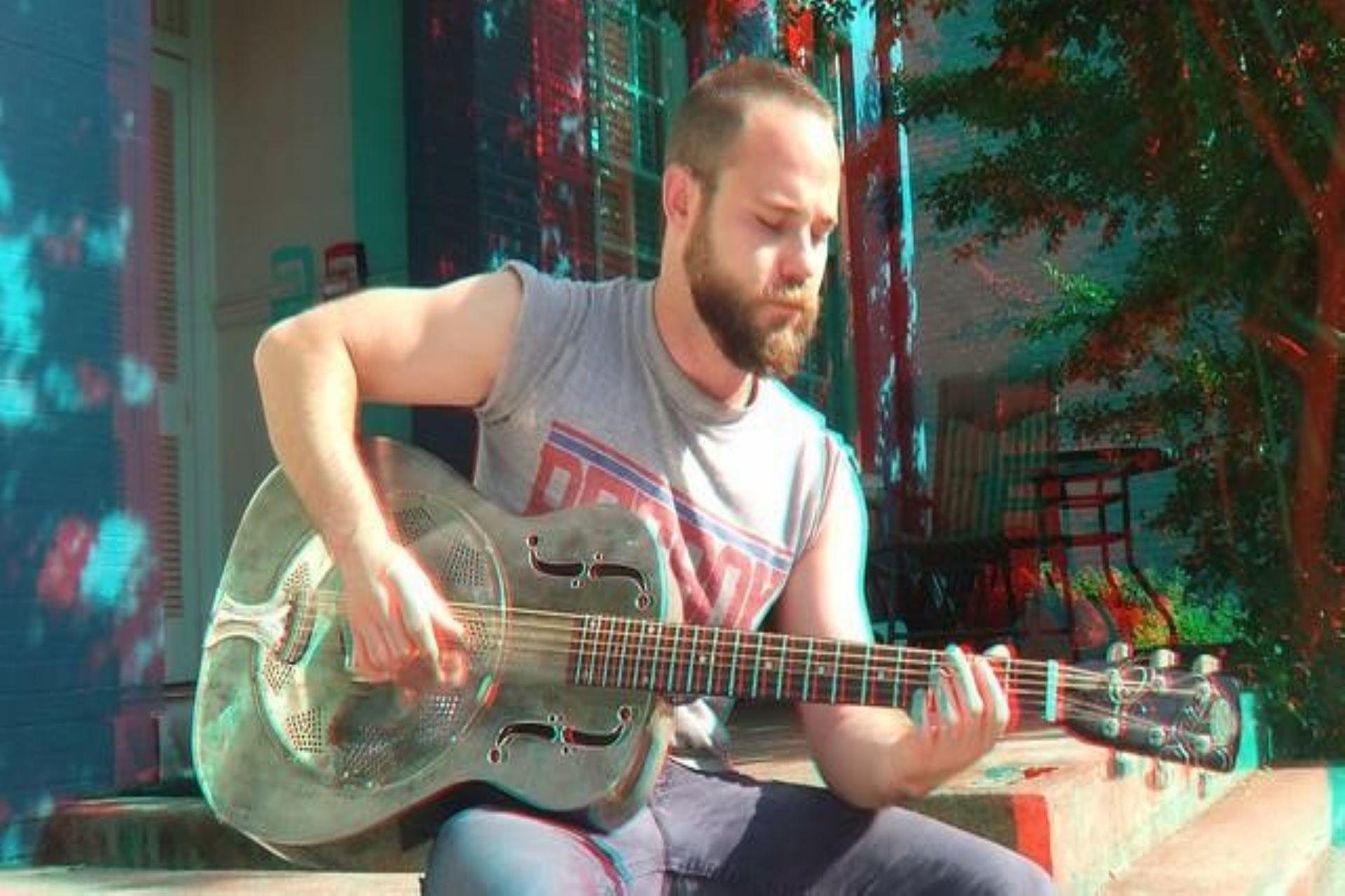 A musician practicing on a resonator guitar