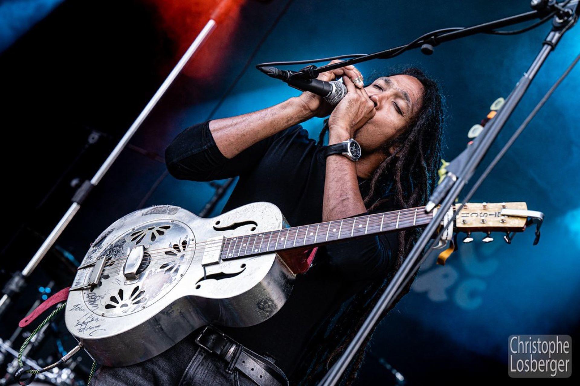A singer performing with a resonator guitar.