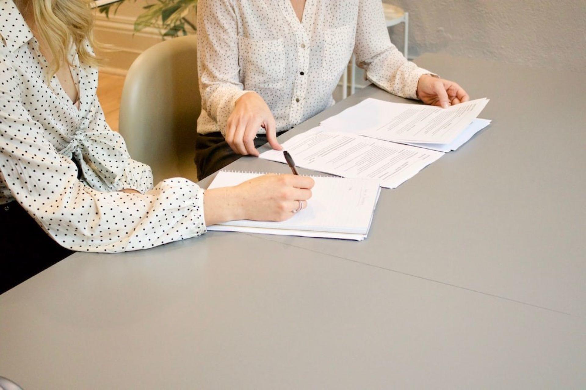 Two women taking notes